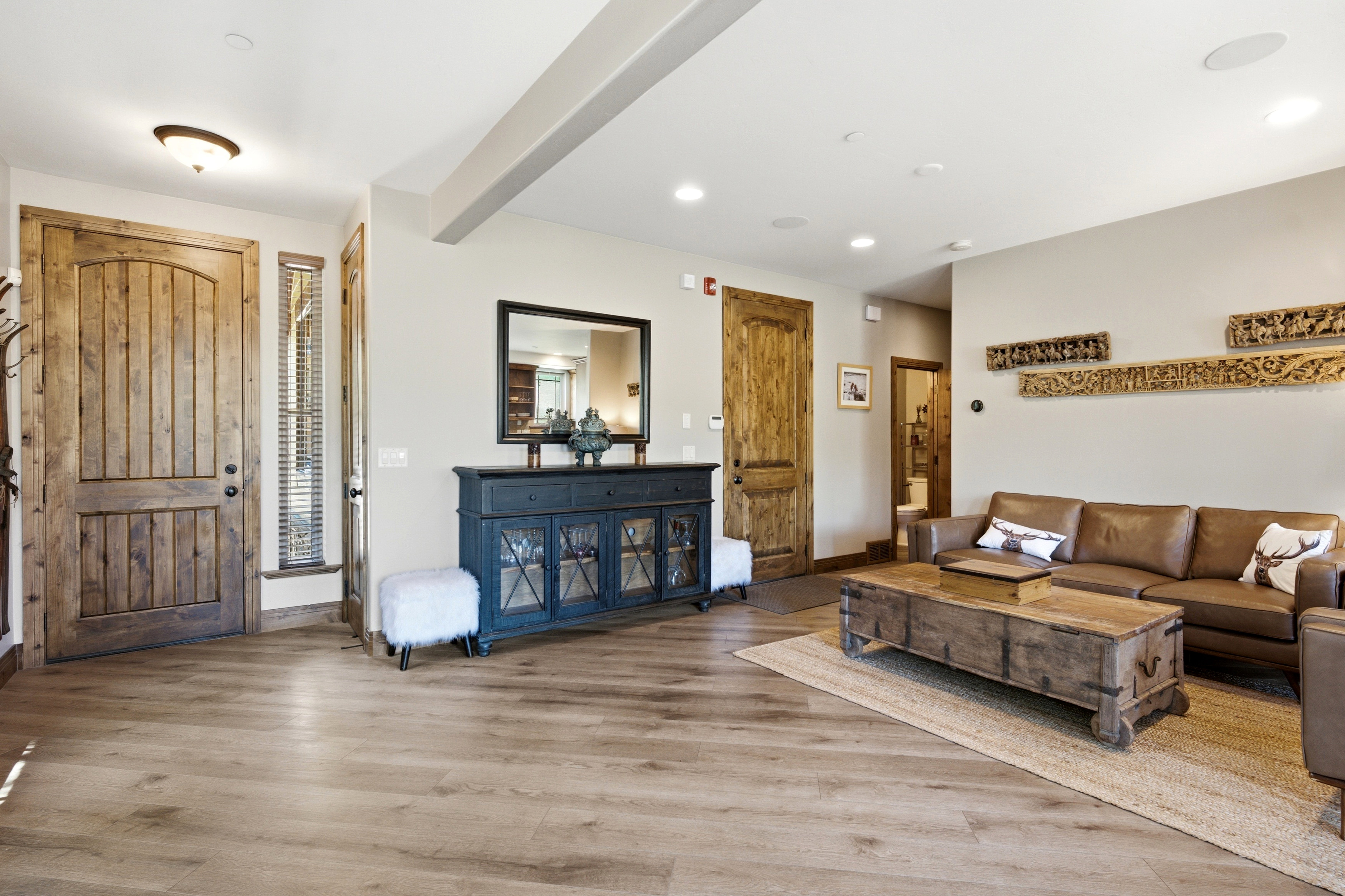 Spacious living area featuring wood-finish flooring, recessed lighting, and a textured accent wall