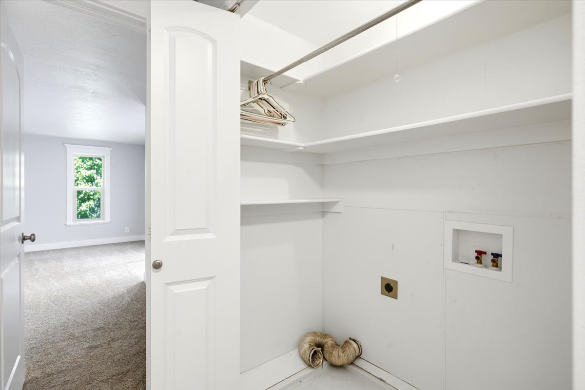 Dedicated laundry area with utility hookups and built-in shelving