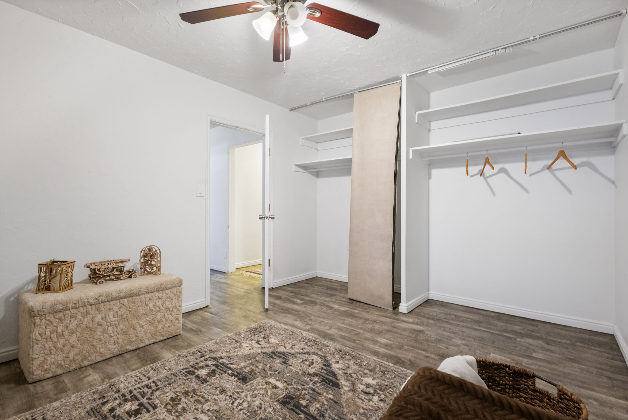 Second bedroom featuring wood-finish flooring and a ceiling fan with light fixture