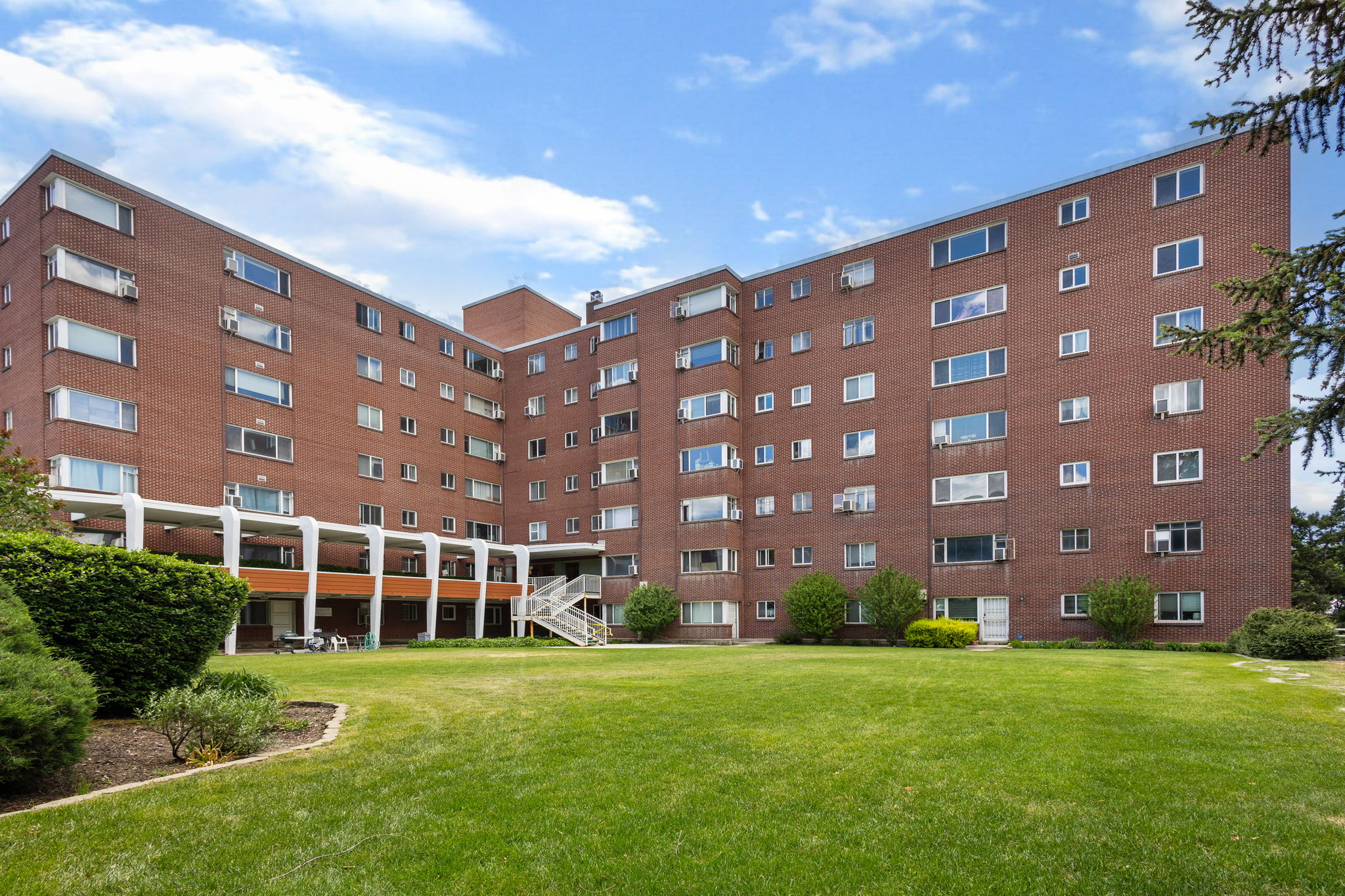 Expansive green lawn fronting a multi-story brick building