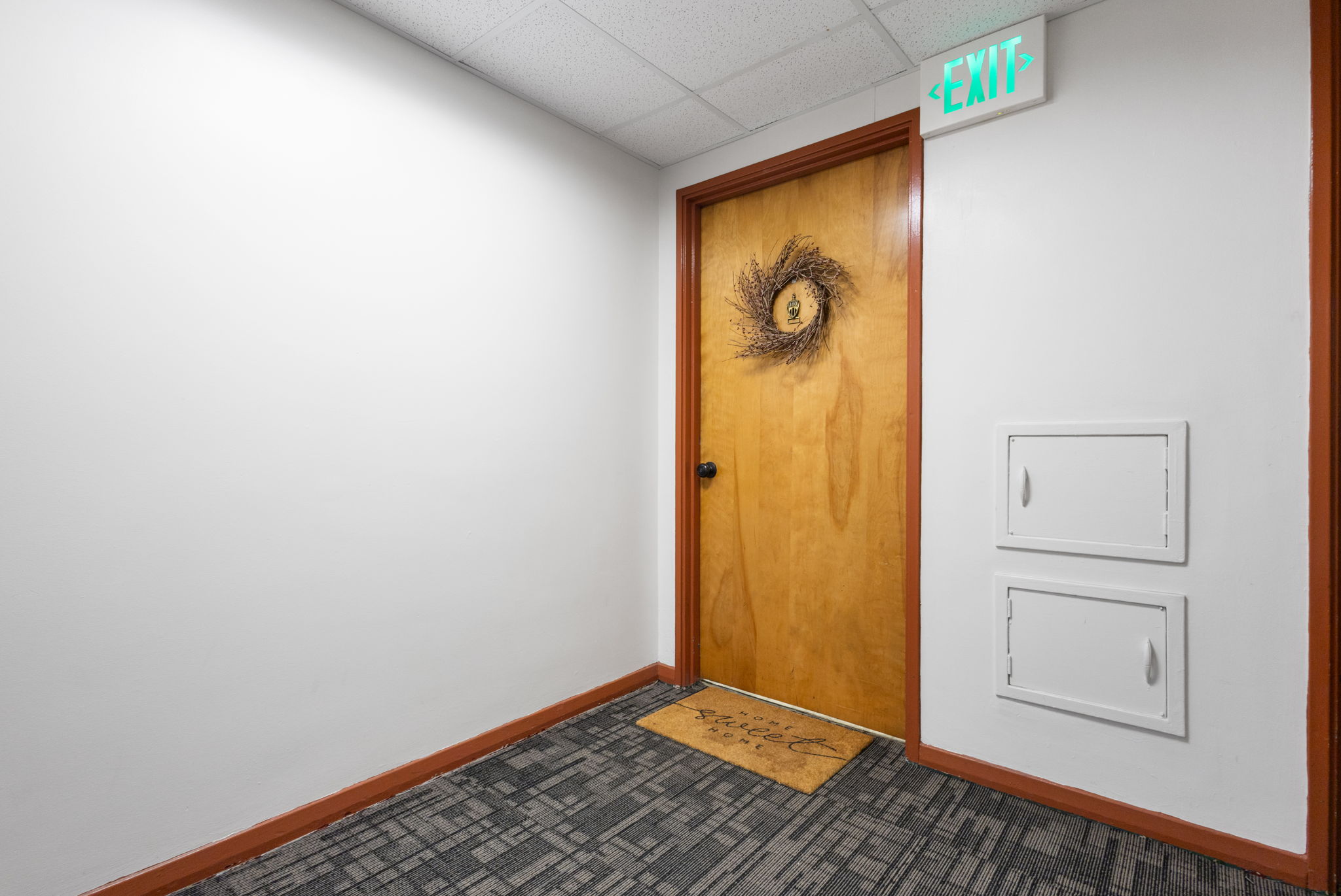 Natural wood-finish entry door with dark hardware