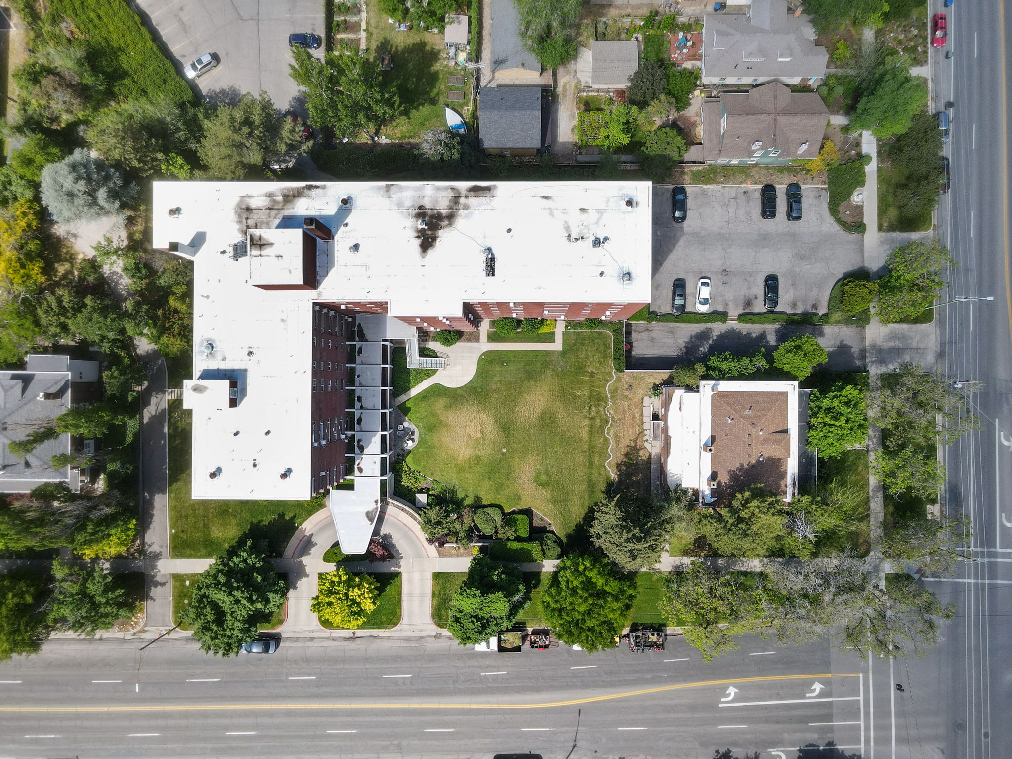 Multi-story brick building with a white roof
