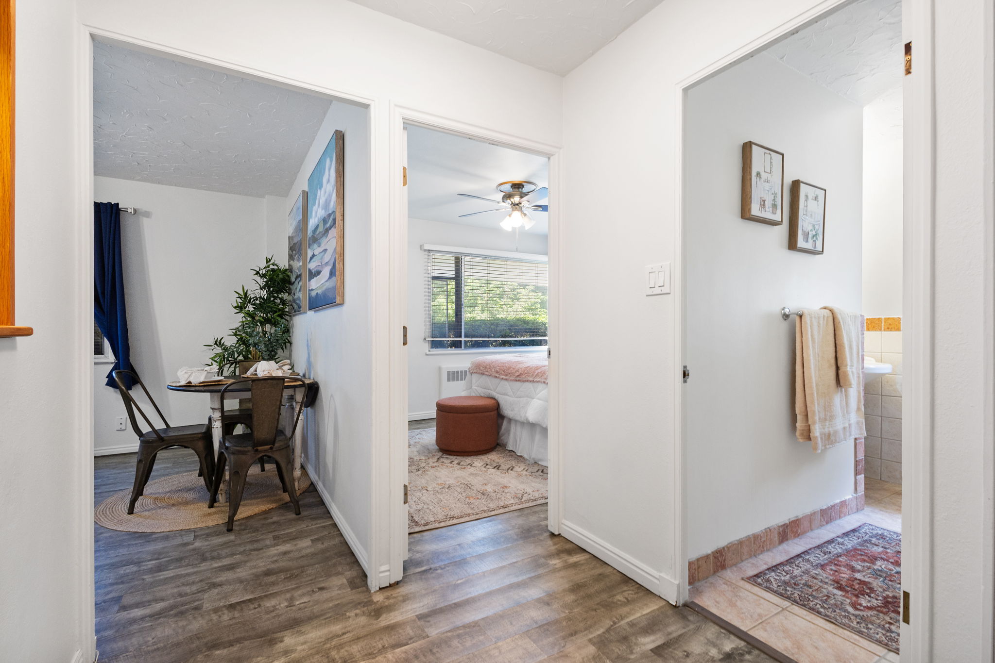 Interior hallway featuring wood-finish flooring, white painted walls, and white trim