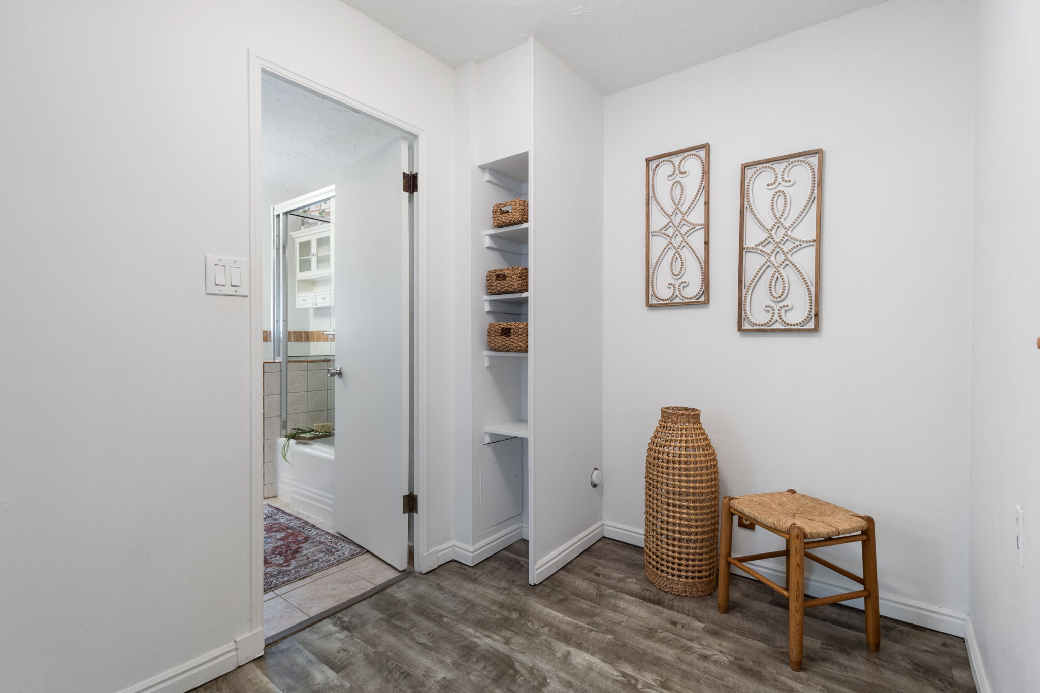 Hallway featuring wood-finish flooring and integrated shelving