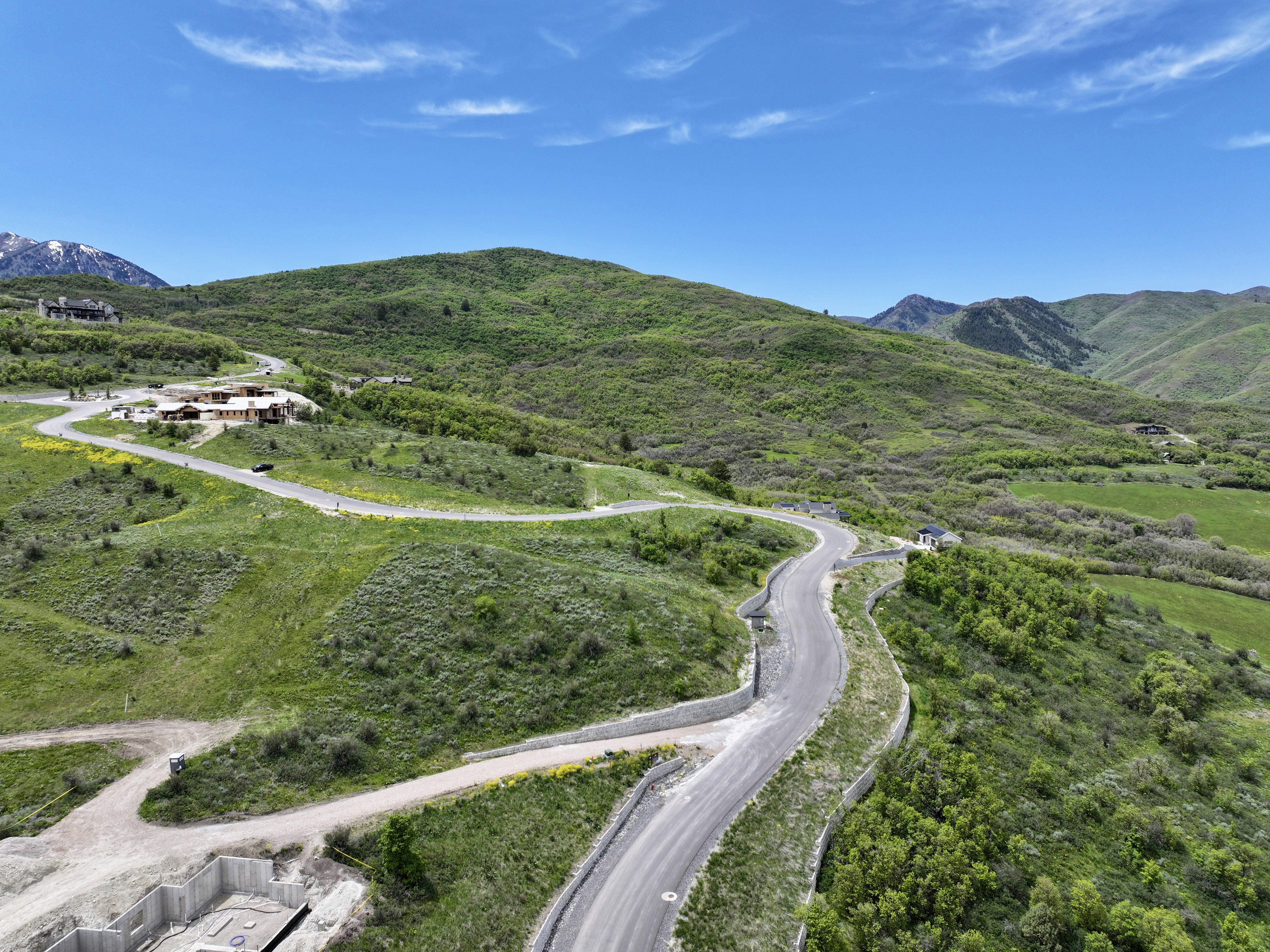 Expansive mountain landscape featuring paved roads and several structures
