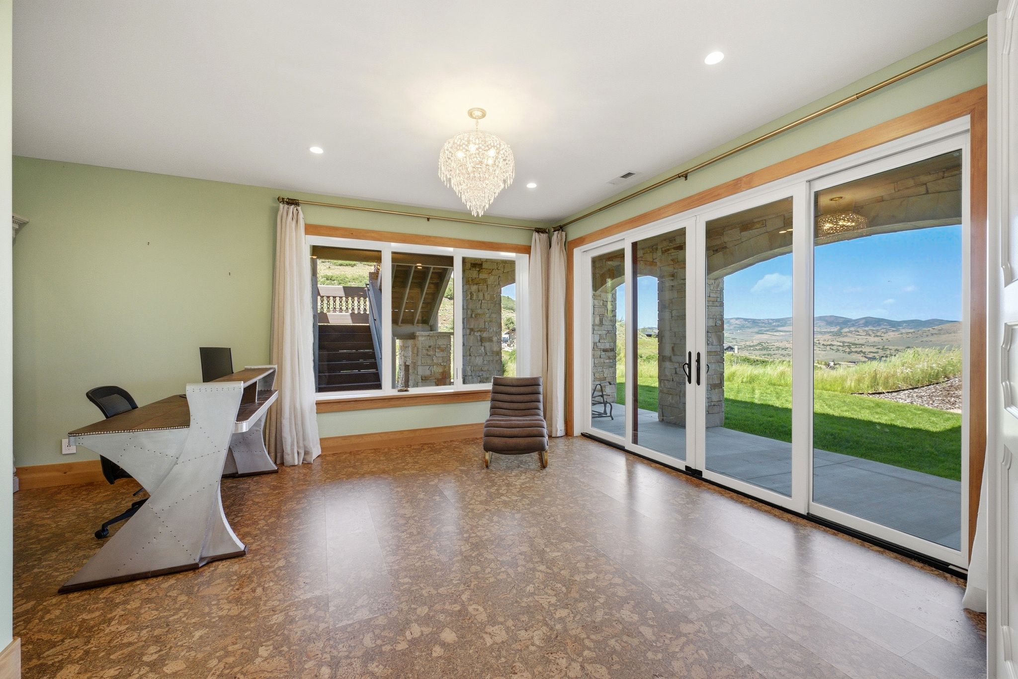 Spacious room featuring cork flooring, a crystal chandelier, and recessed lighting