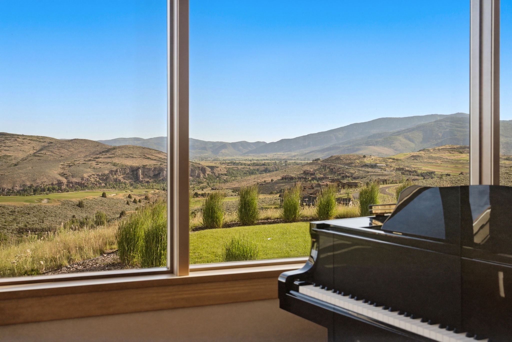 Expansive window framing panoramic mountain and valley scenery