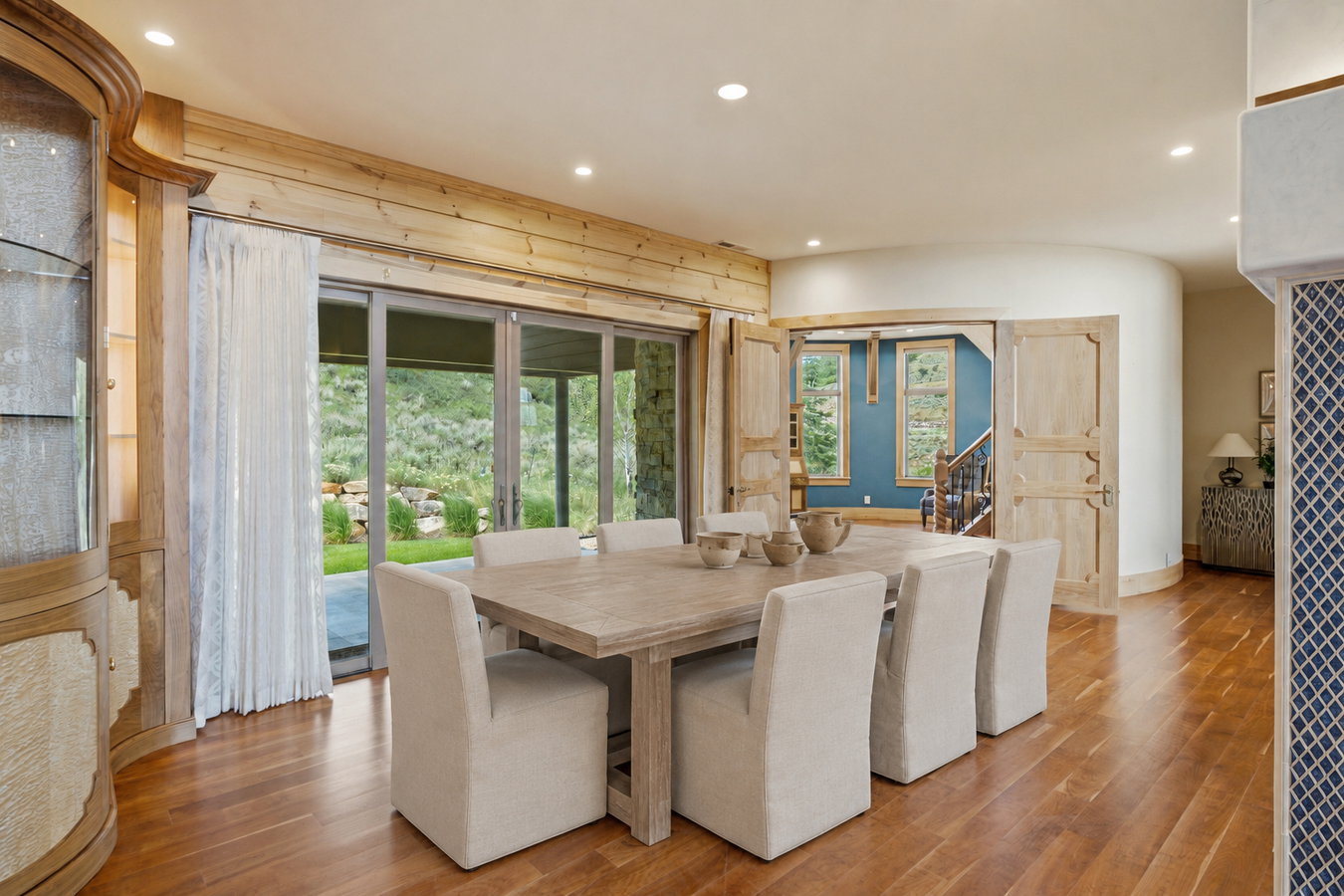 Formal dining area featuring wood-finish flooring, recessed lighting, and a built-in display cabinet