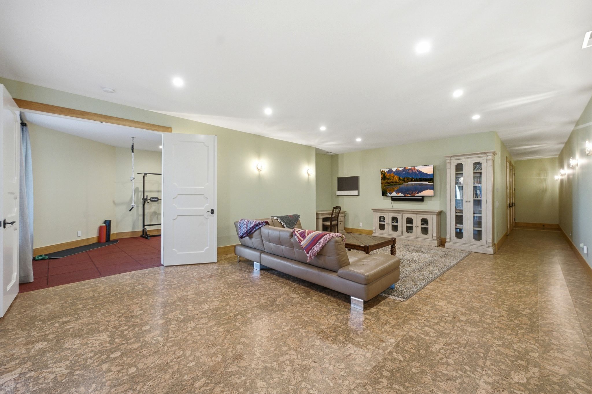 Spacious room featuring patterned flooring, recessed lighting, and soft green wall tones