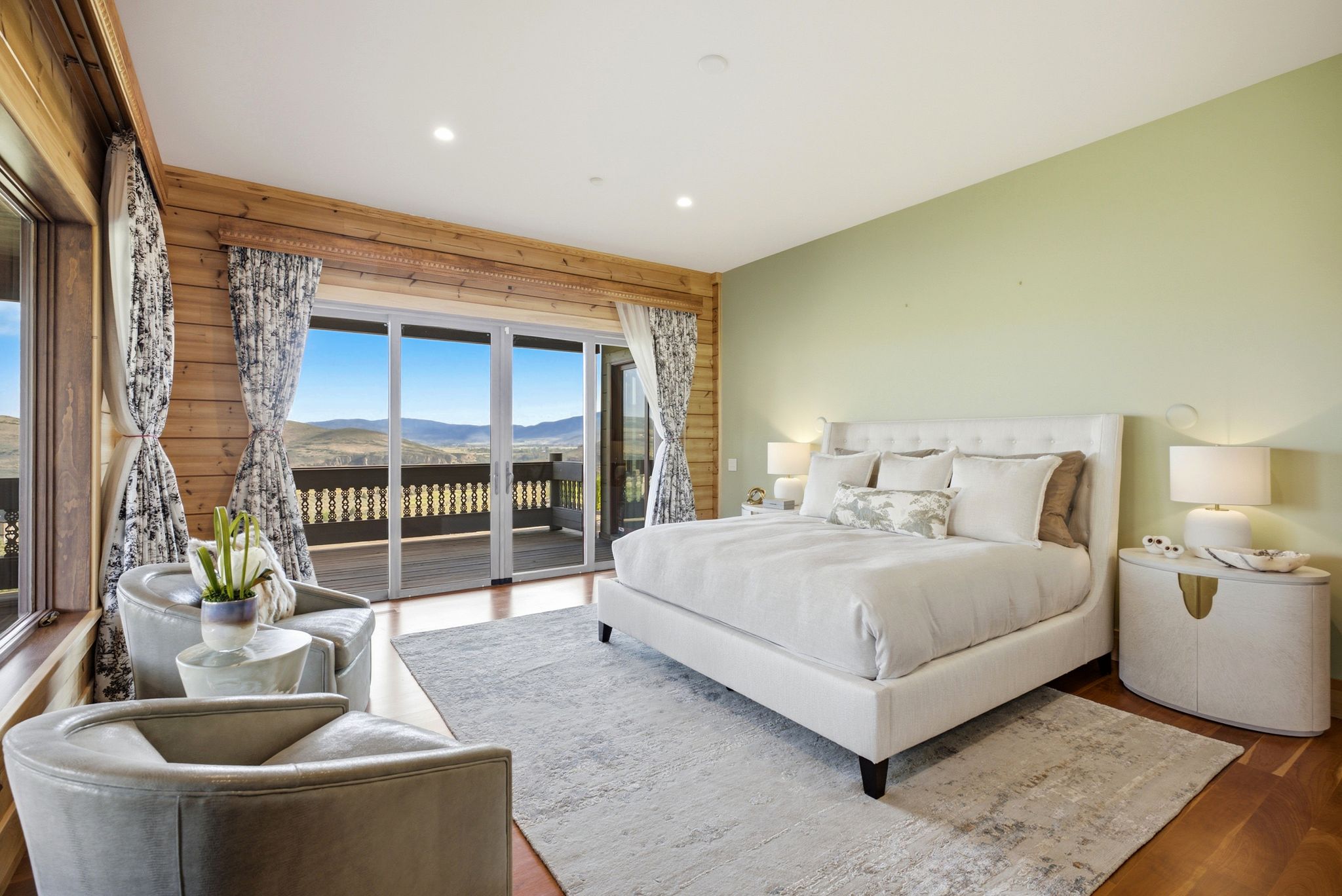 Spacious room featuring wood-finish flooring and a light green wall