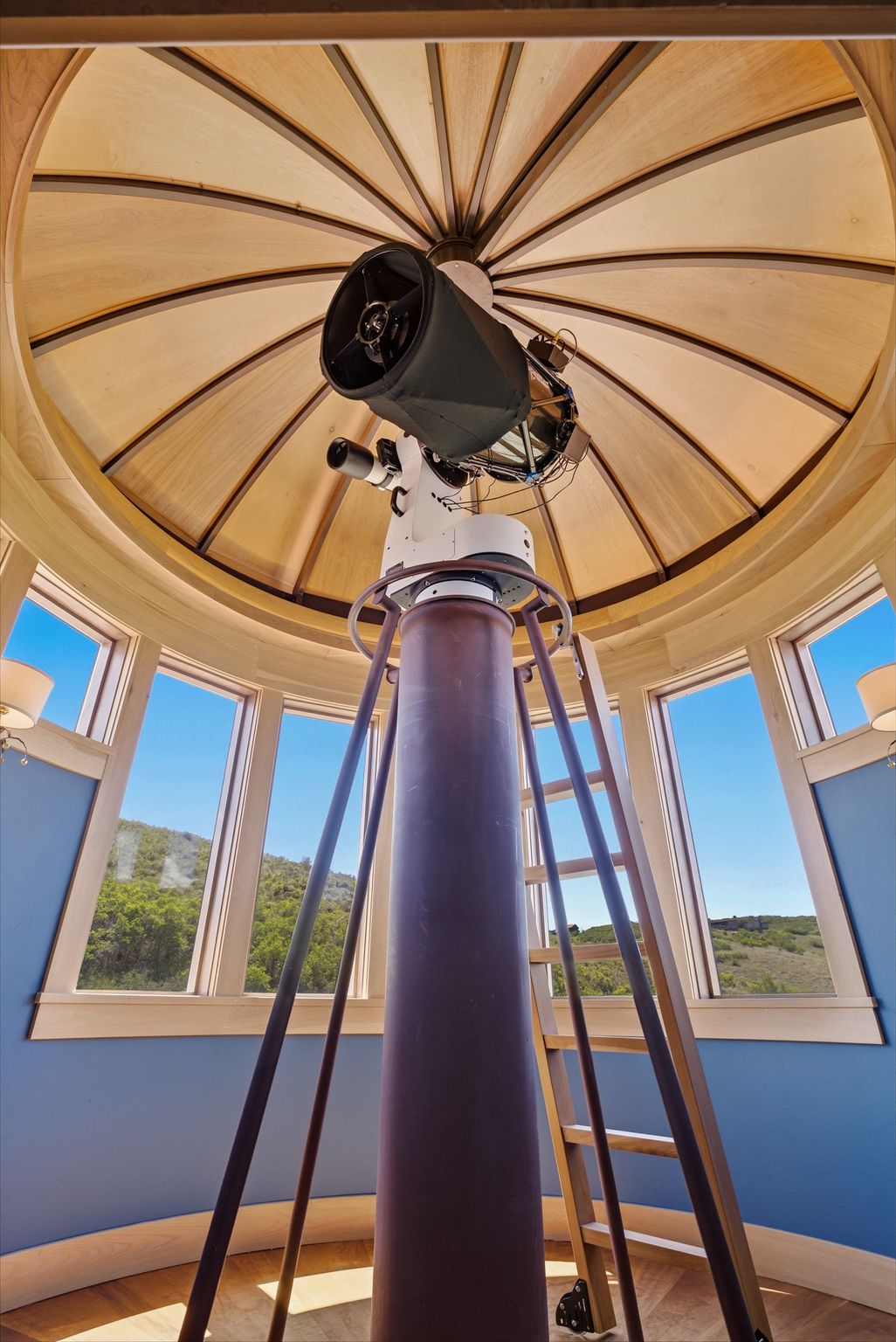 Custom observatory featuring a domed wood-paneled ceiling, a central column, and a circular array of windows