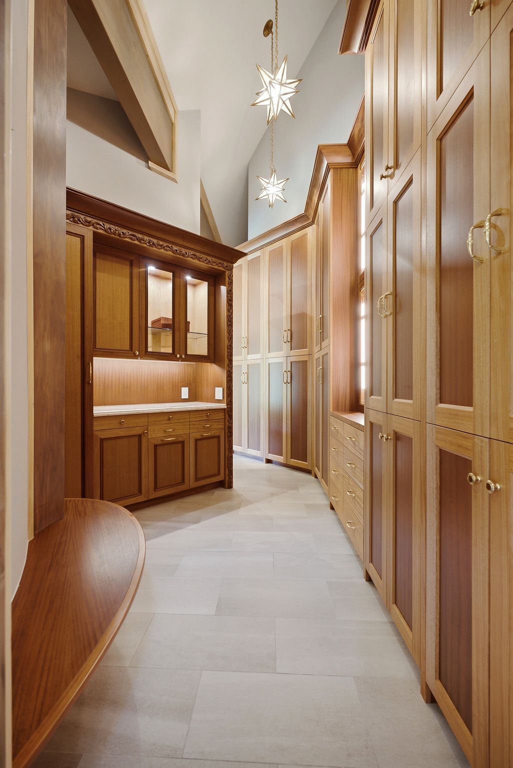 Custom cabinetry featuring light and dark wood finishes, integrated lighting, and brass hardware