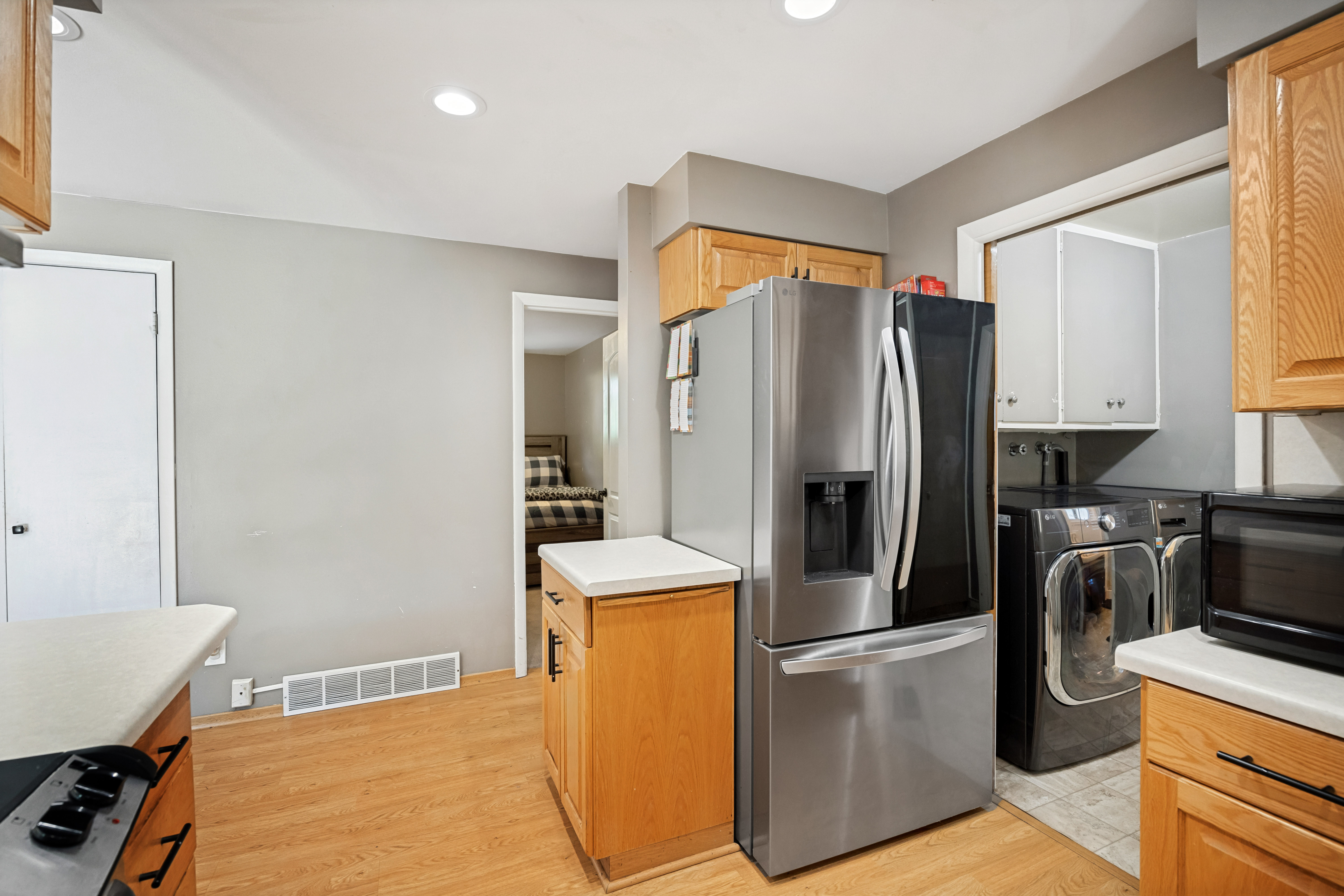 Kitchen area featuring recessed lighting, wood-finish flooring, and light-toned cabinetry with contrasting hardware