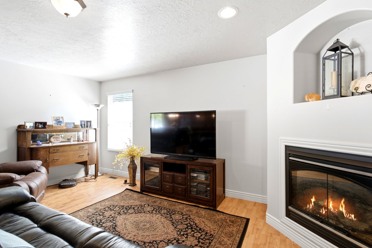 Living area featuring a built-in fireplace, recessed lighting, and wood-finish flooring
