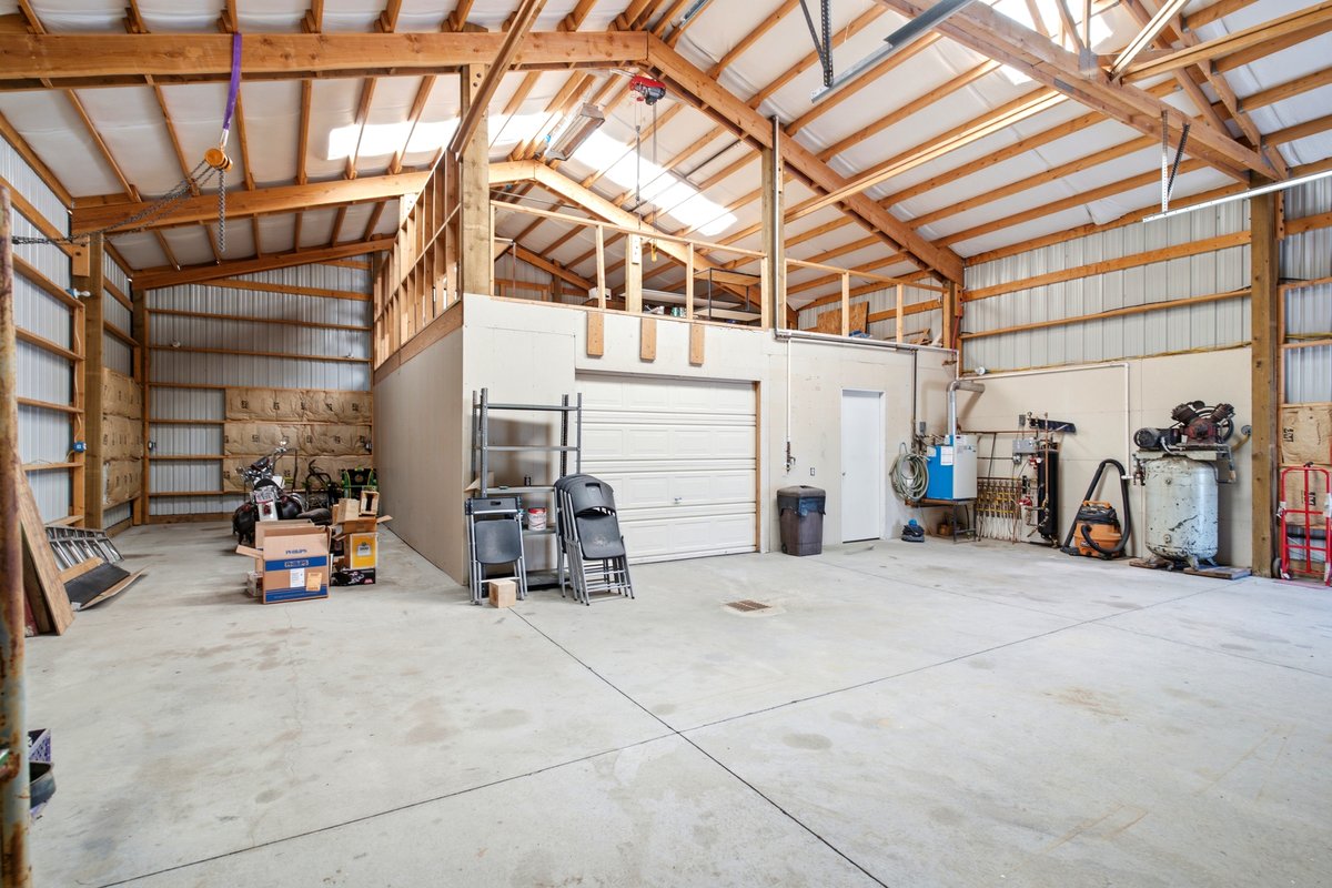 Spacious workshop with concrete flooring and exposed wood beam construction