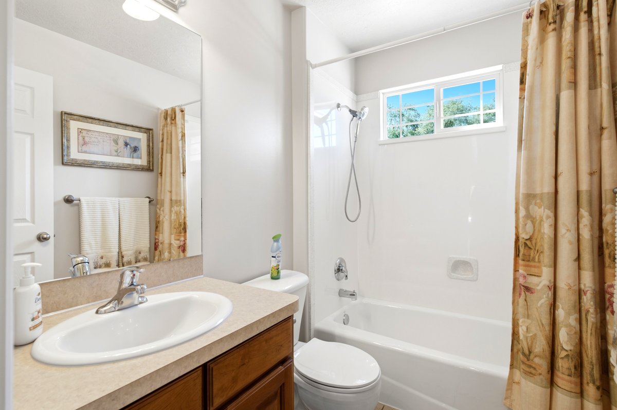 Bathroom featuring a wood-finish vanity with an integrated sink and a light-toned countertop