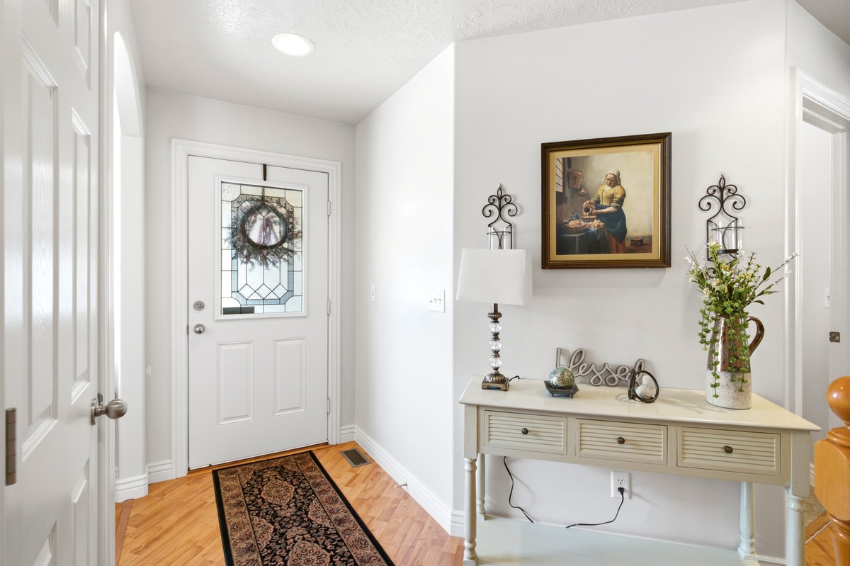 Entryway featuring a decorative front door with leaded glass, light wood-finish flooring, a recessed ceiling light, and a white console table with three drawers