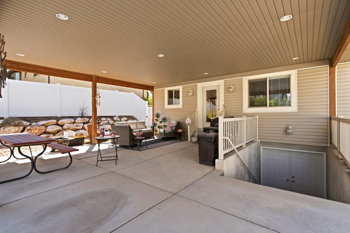 Expansive covered patio featuring concrete flooring, recessed lighting, and support beams with a wood finish