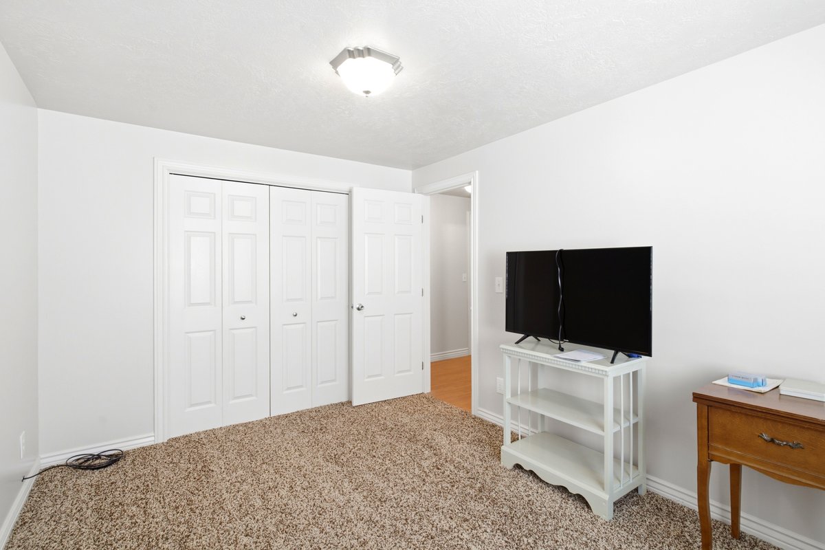 Bright room with neutral wall paint and textured carpet flooring