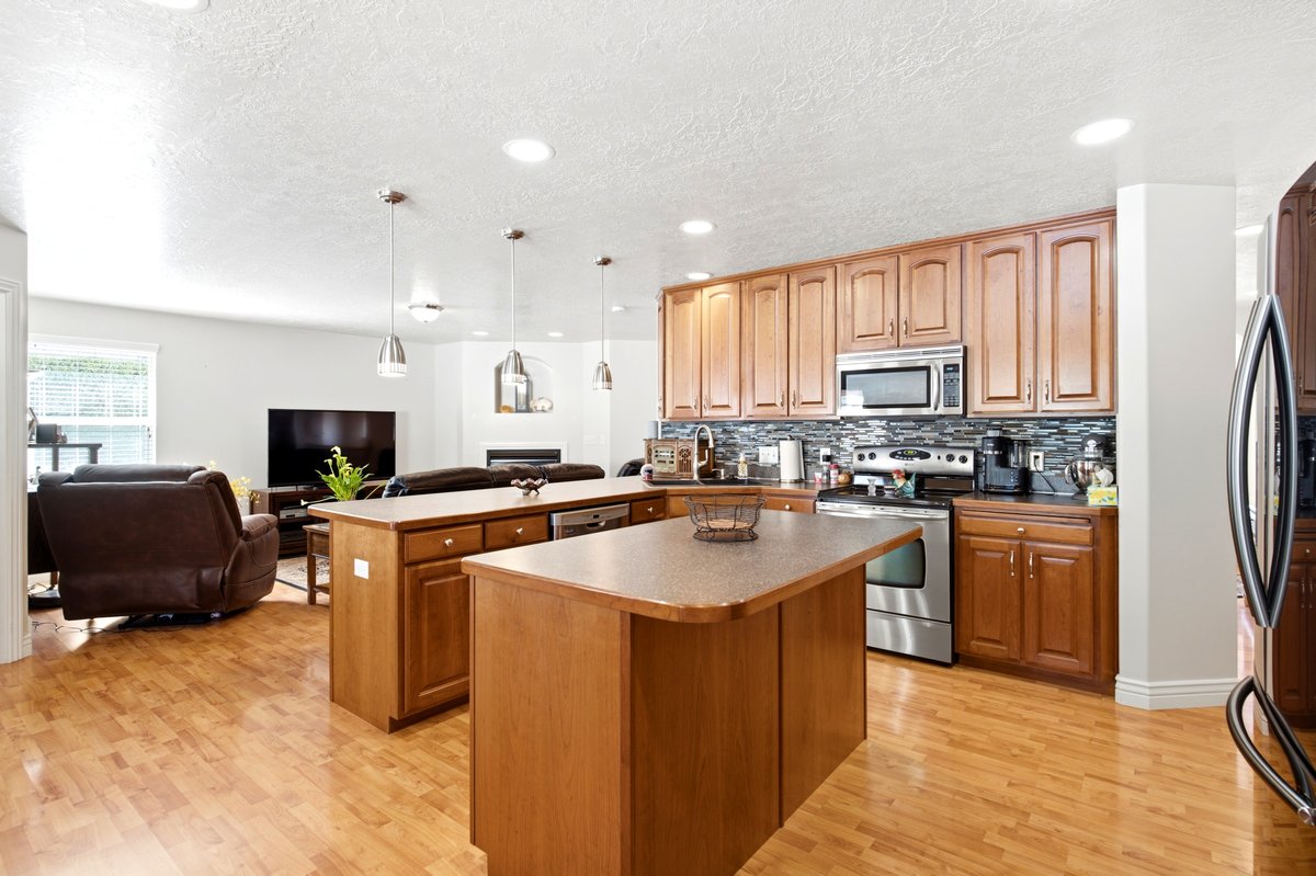 Kitchen featuring wood-finish cabinetry, stainless steel appliances, and a tiled backsplash