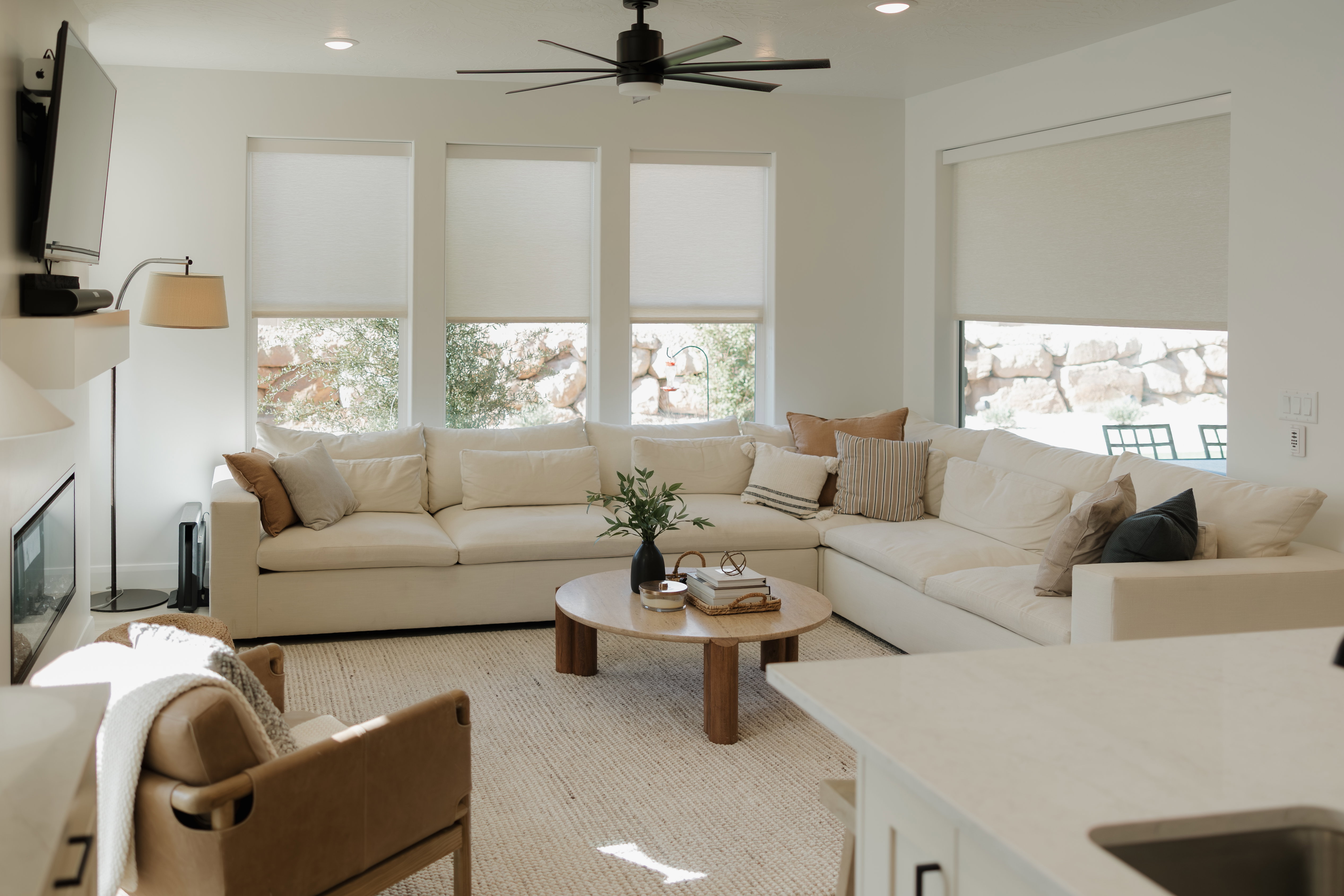 Open-concept living space featuring a modern linear fireplace, multiple large windows, recessed lighting, and a ceiling fan