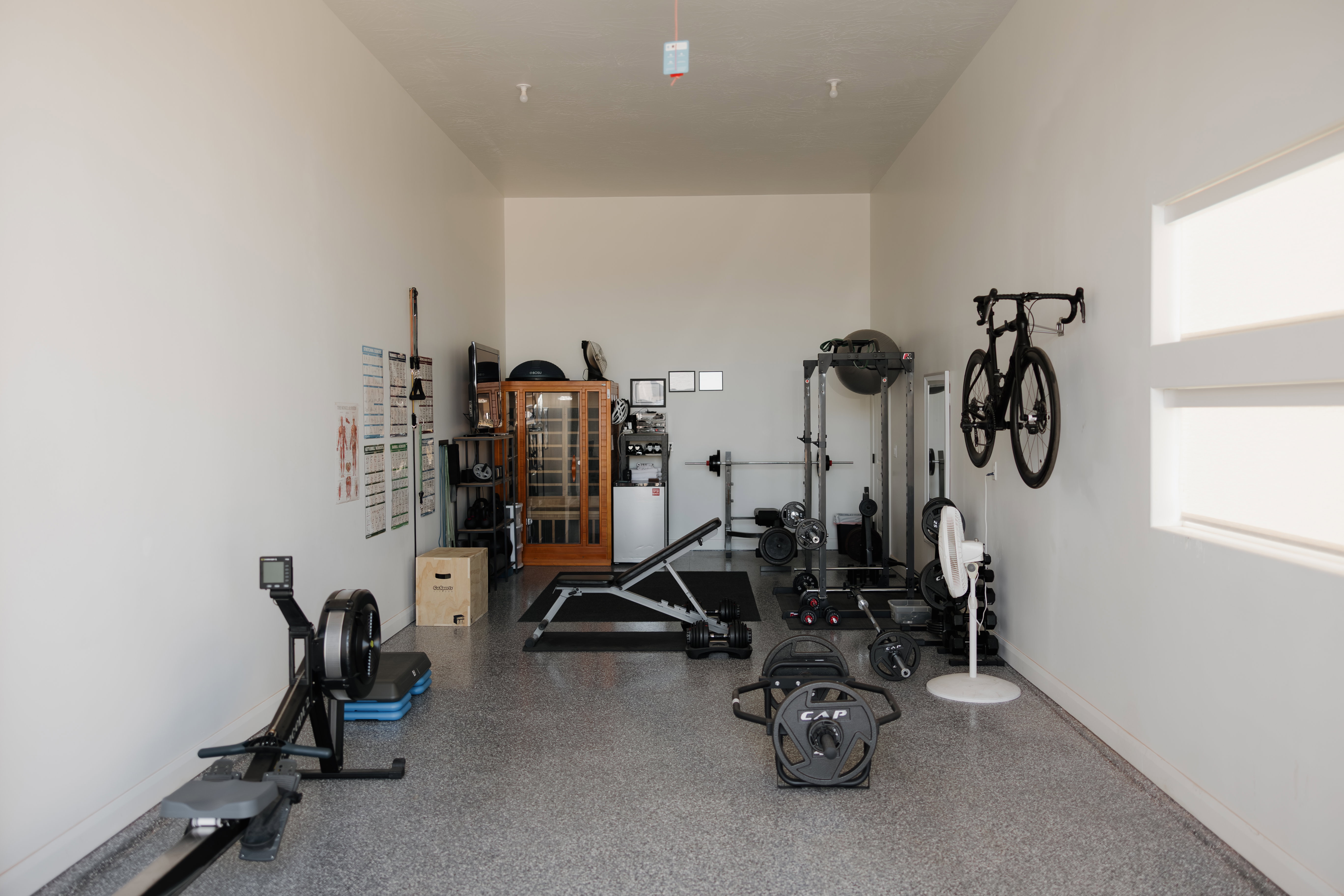 Spacious interior room featuring light-colored walls and a speckled epoxy floor finish