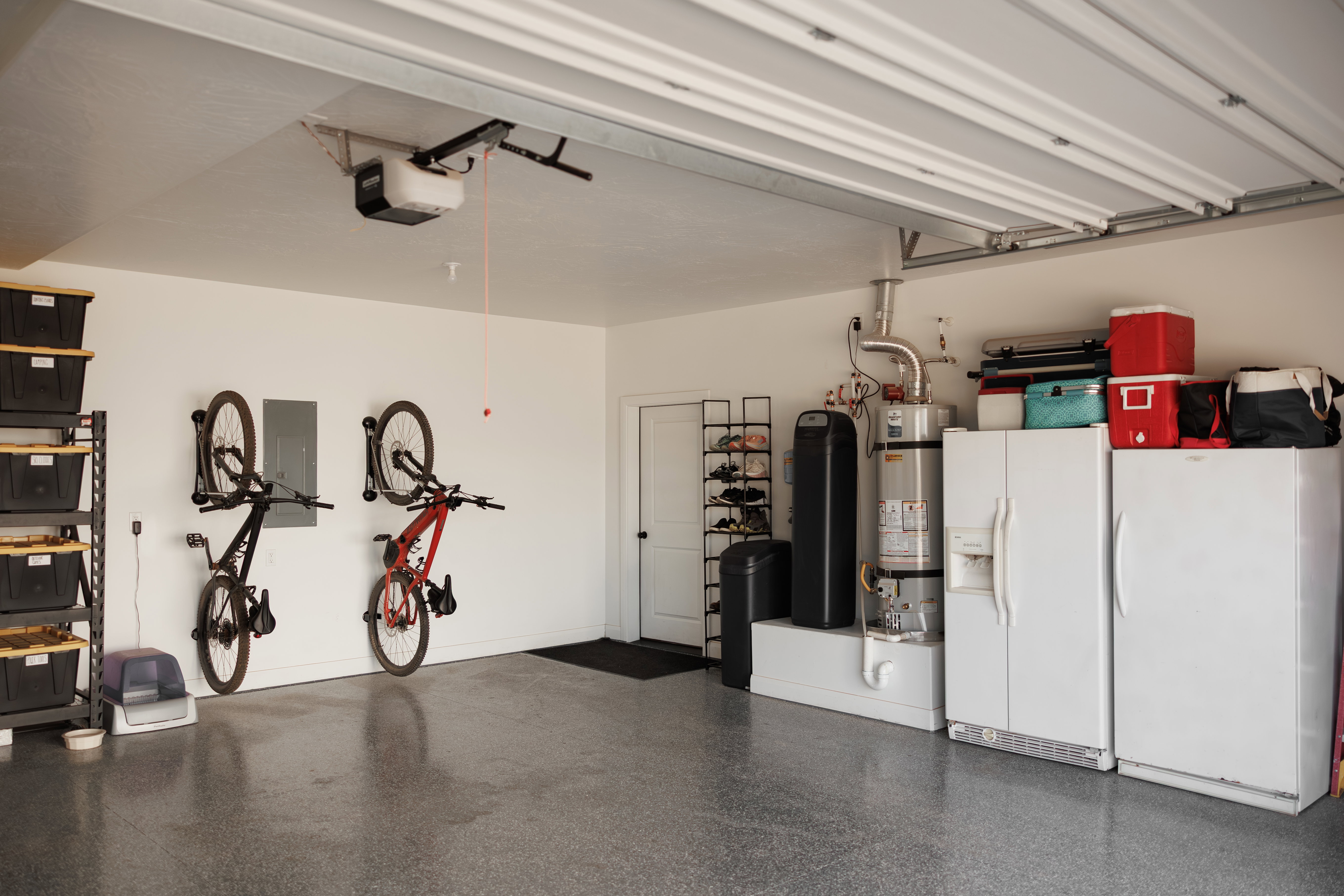 Spacious garage featuring a durable epoxy floor coating and bright overhead lighting