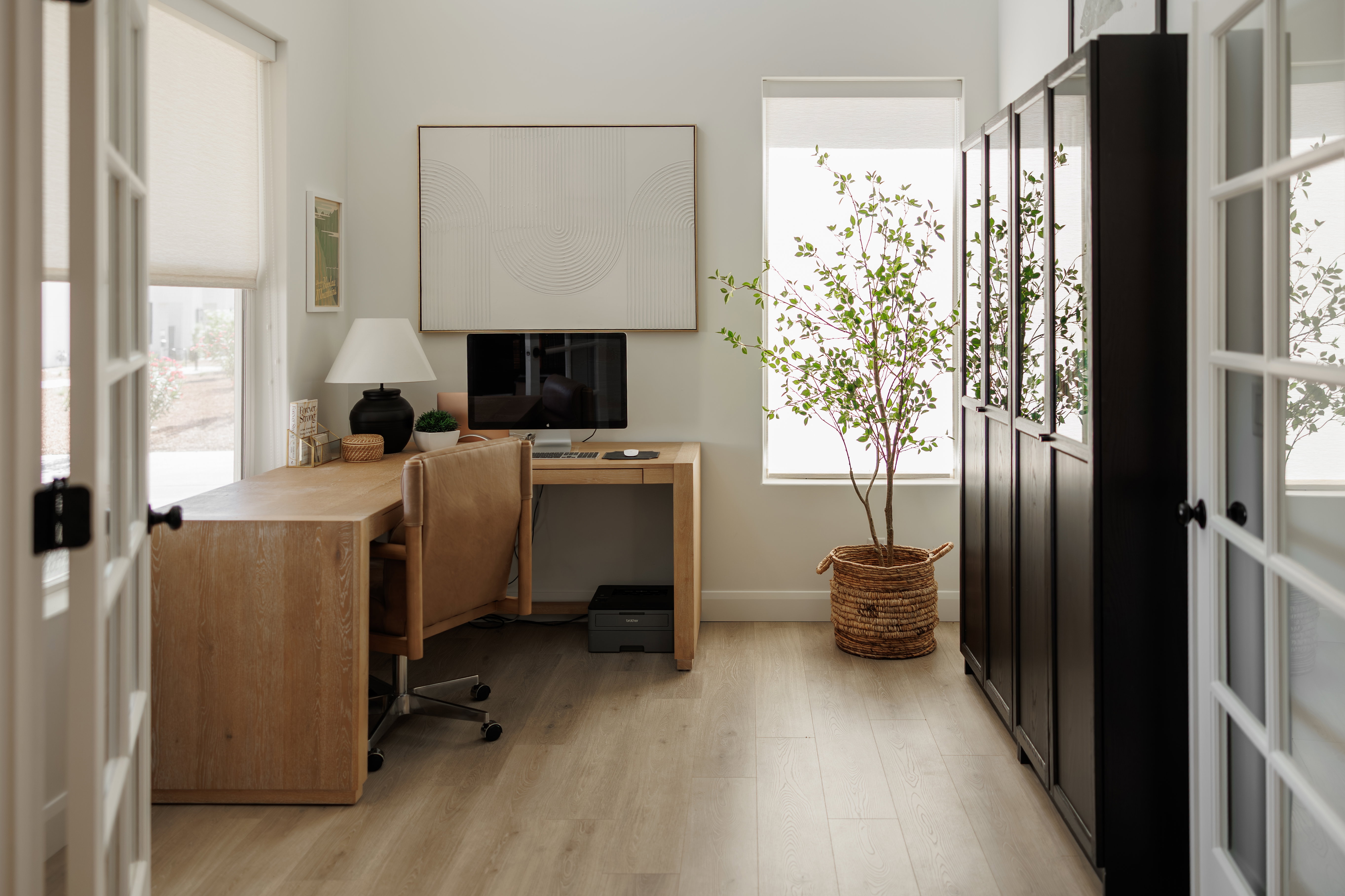 Light wood-finish flooring complements white walls and French doors with black hardware