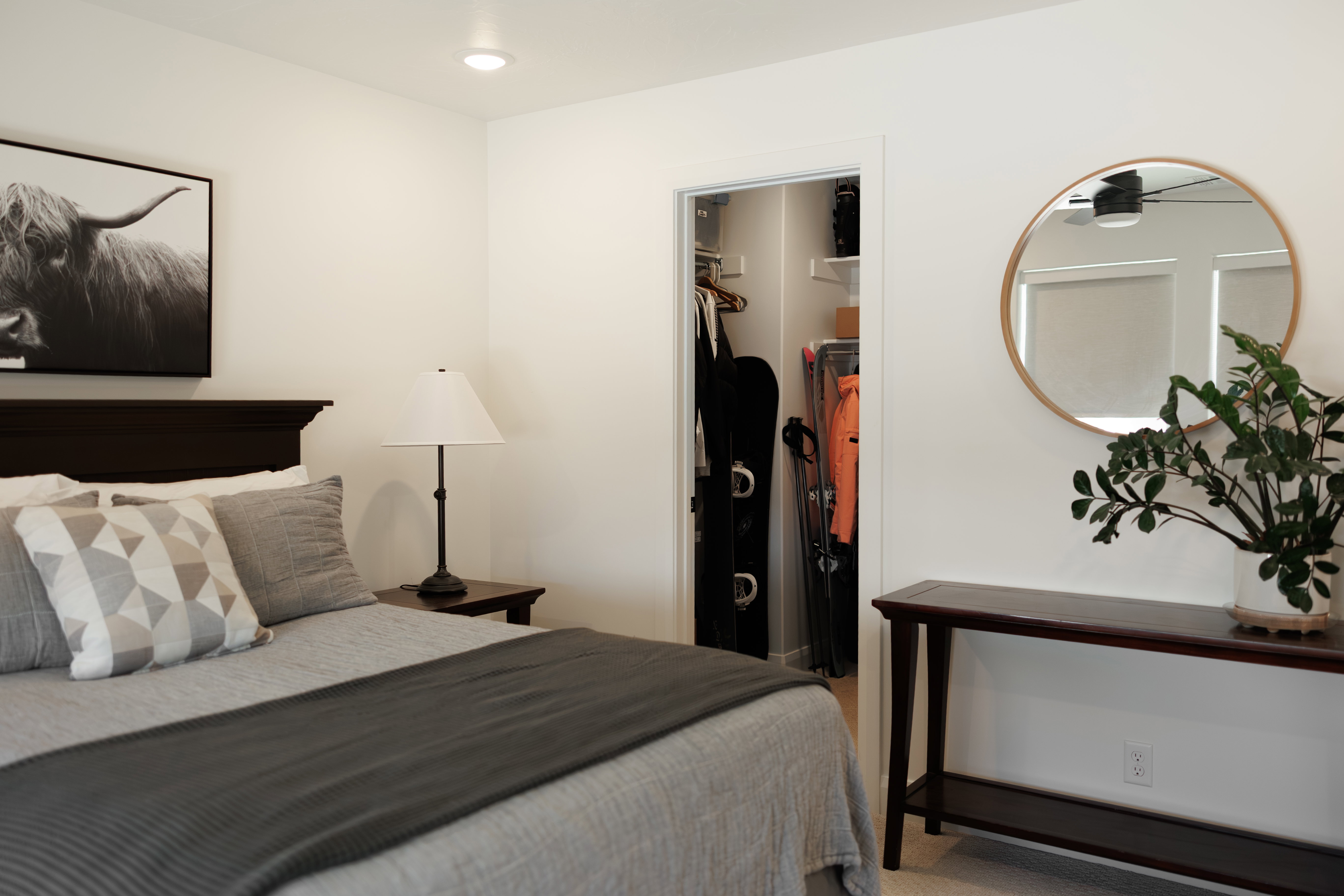 Bedroom featuring a dark wood headboard, recessed lighting, and a closet with built-in shelving