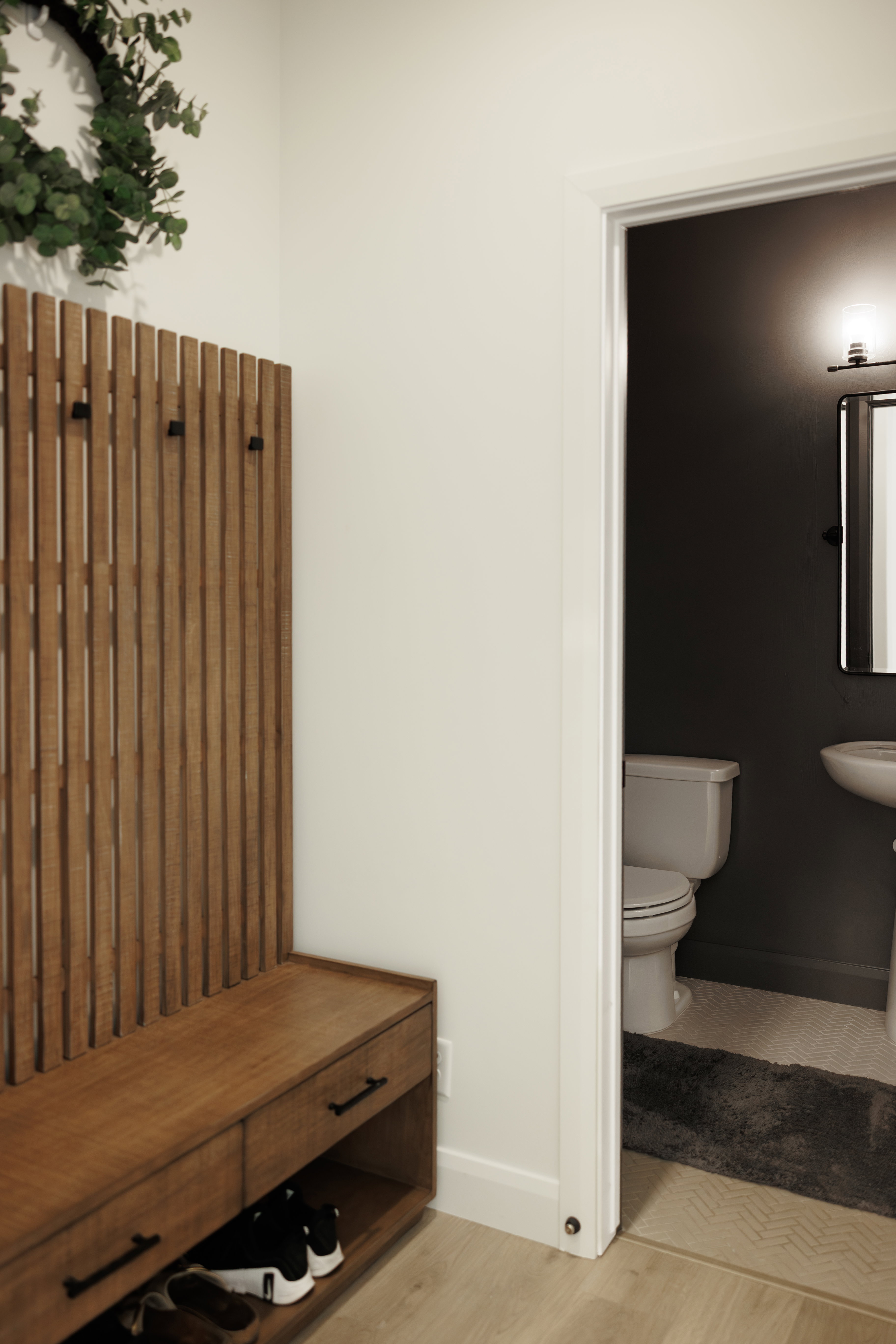 Built-in wood-finish entryway organization with integrated hooks and storage drawers