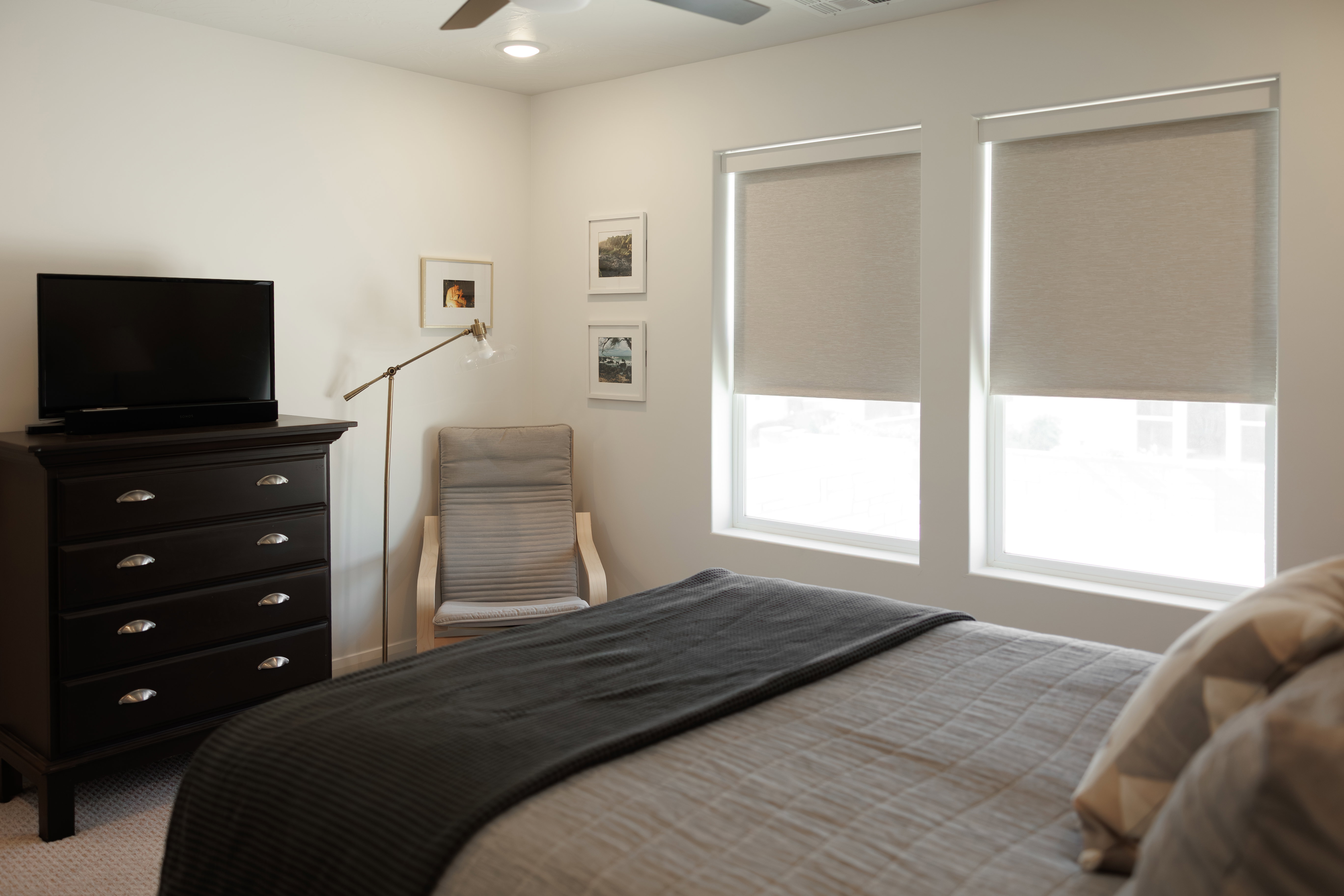 Bedroom featuring two windows with roller shades, recessed lighting, and a ceiling fan