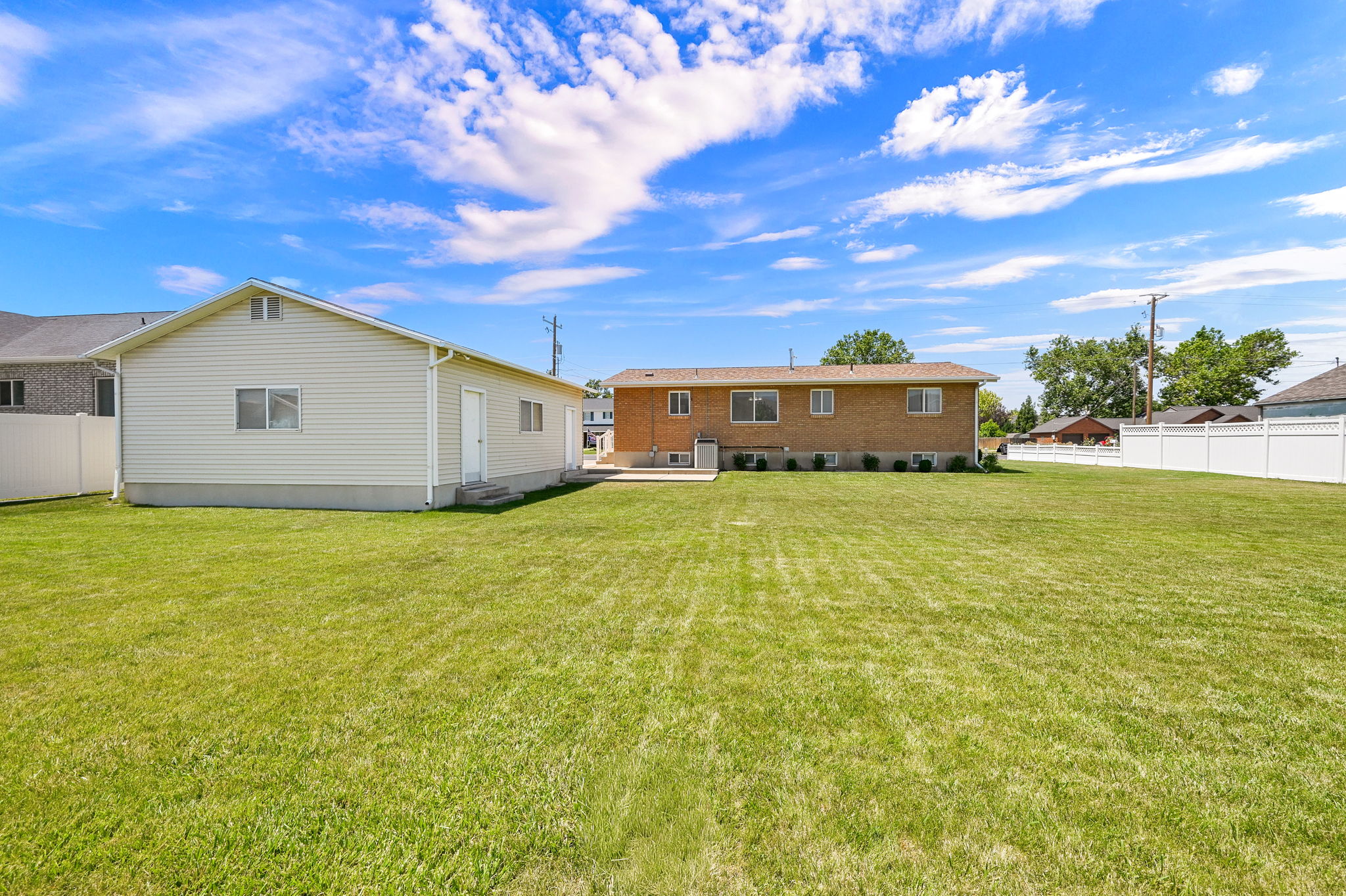 Expansive green lawn with a vinyl privacy fence