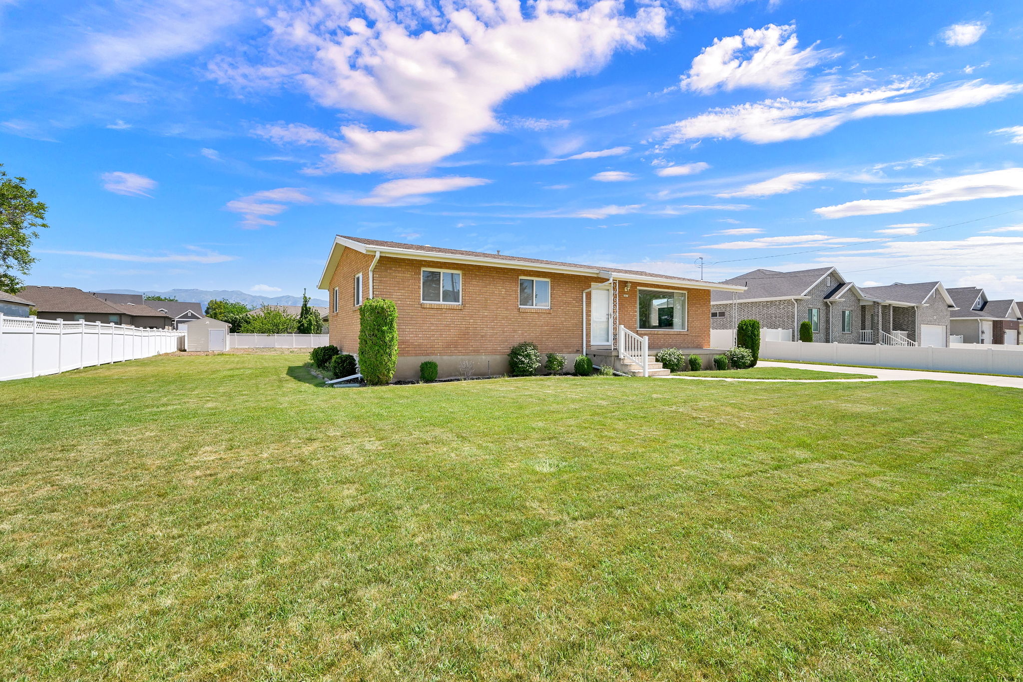Spacious exterior with an expansive green lawn and a full vinyl fence