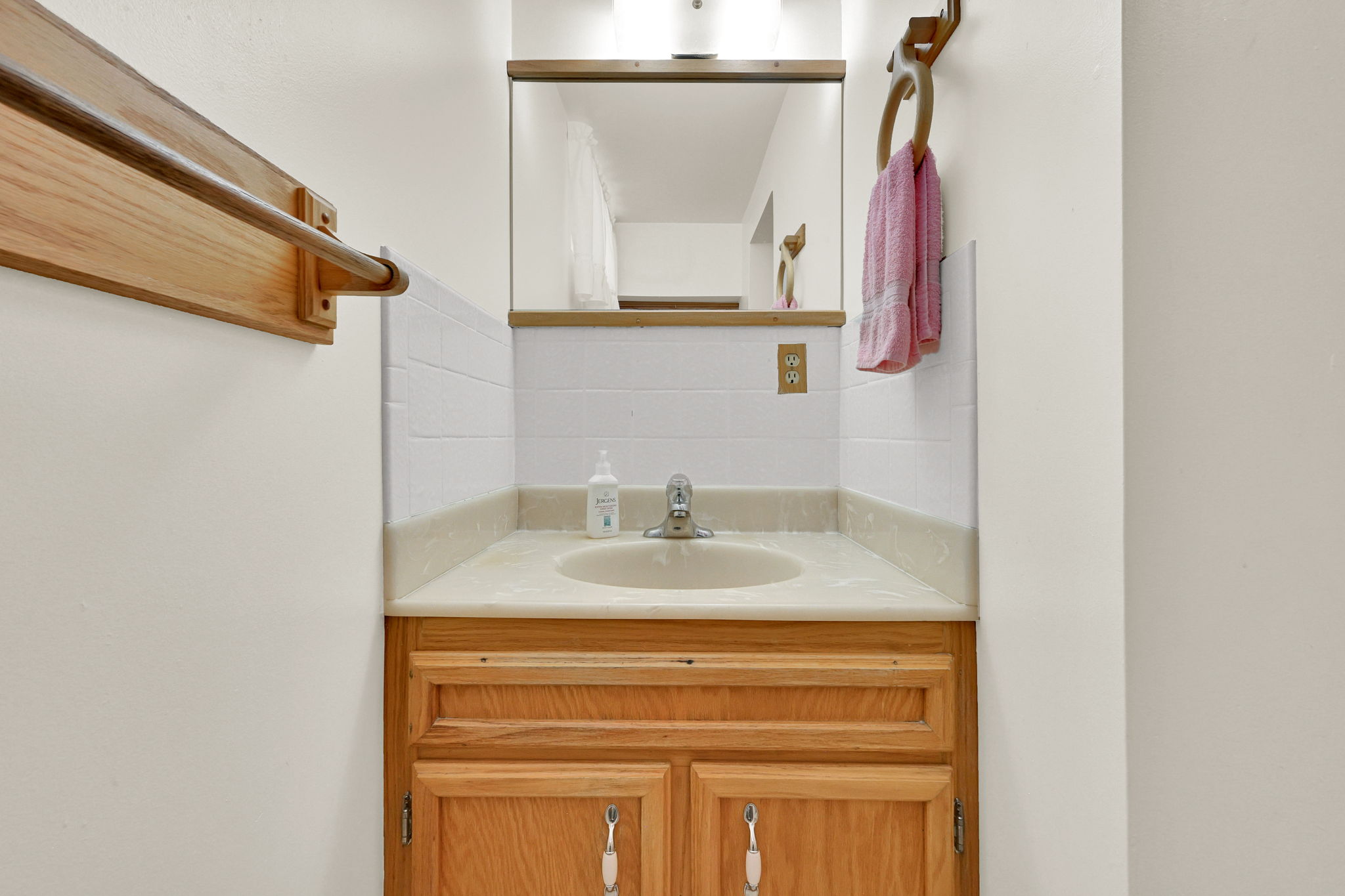 Wood-finish vanity with an integrated sink and light-toned countertop