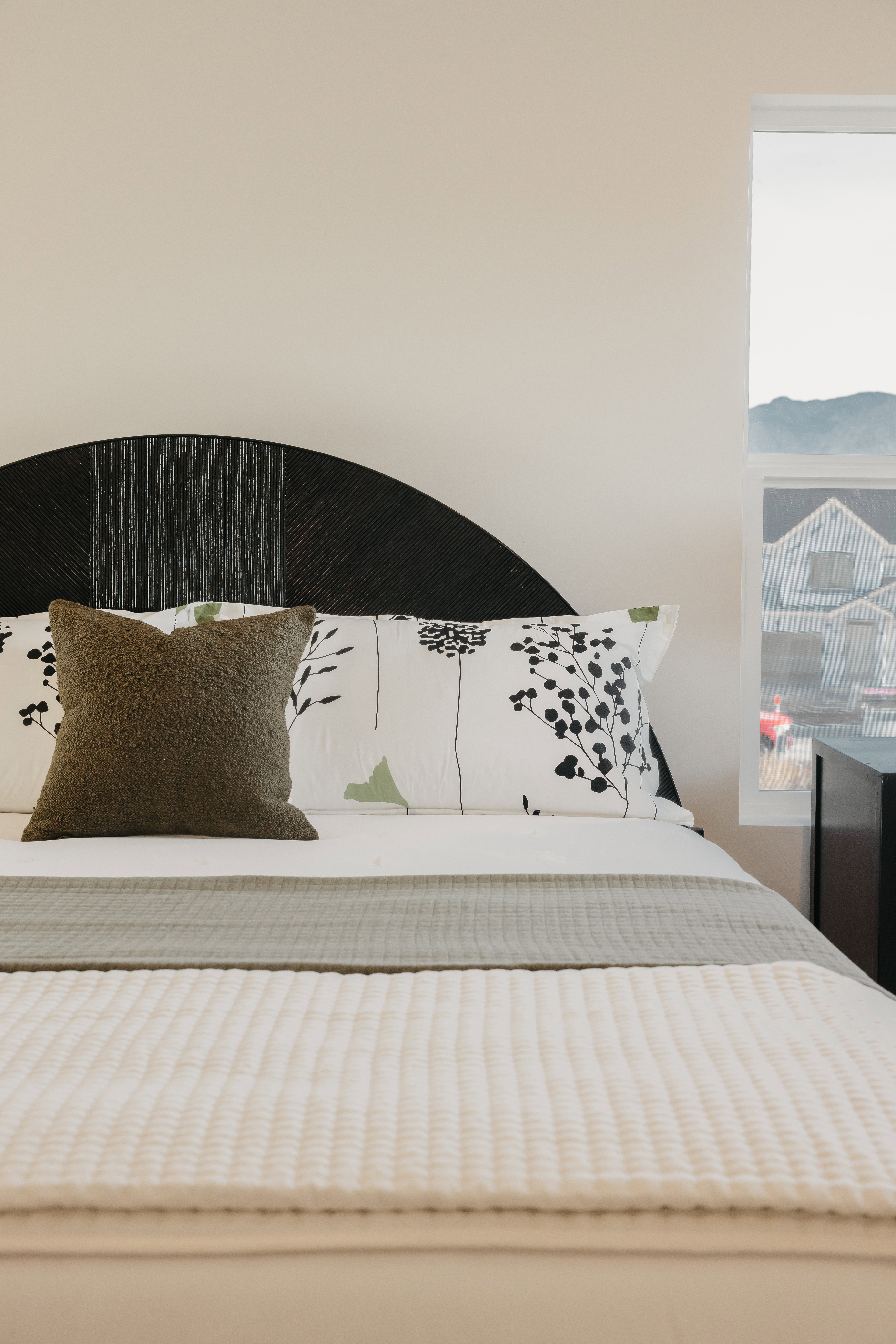 Bedroom featuring a distinctive curved dark wood headboard with textured detailing