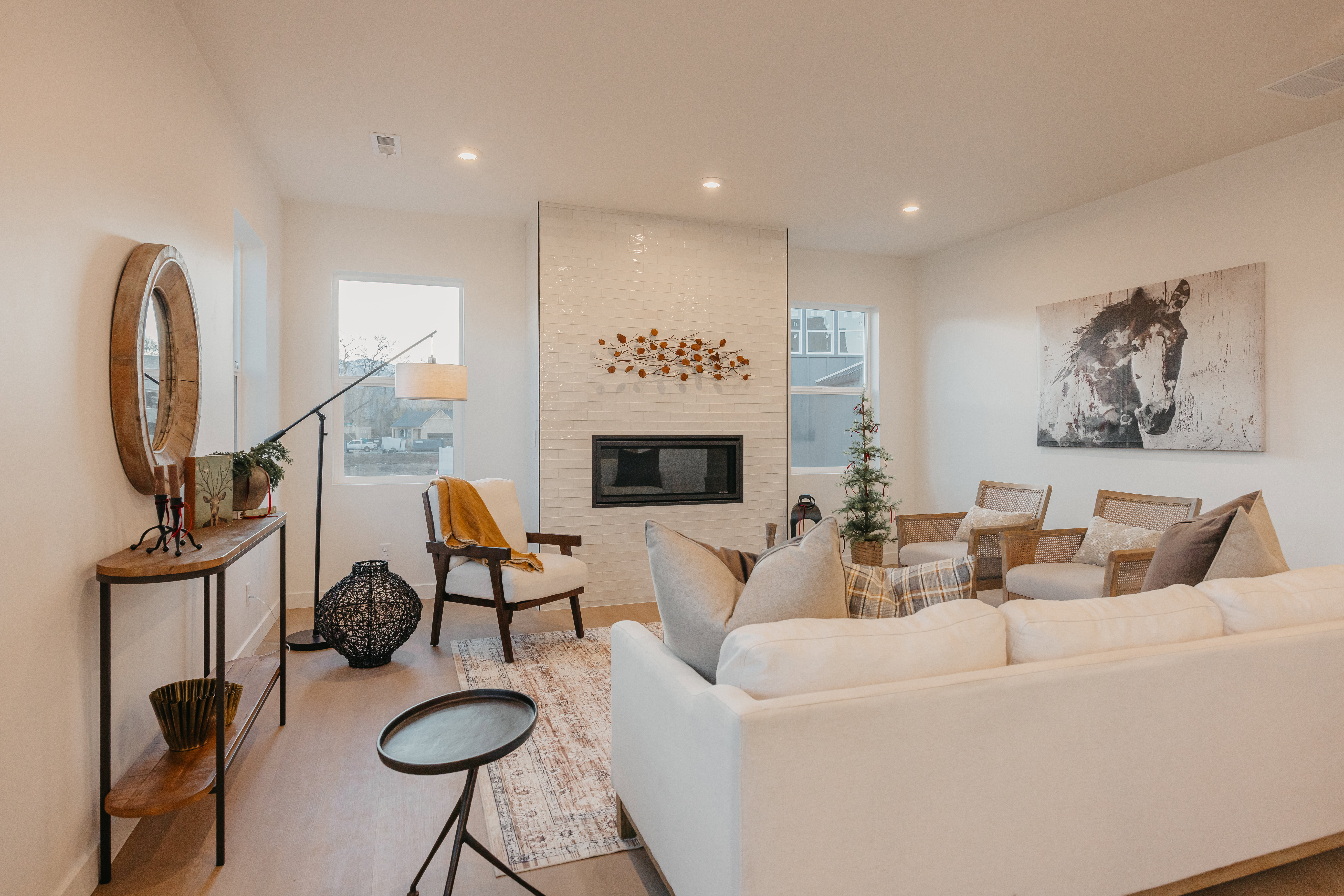 Open-concept living space featuring light wood-finish flooring, recessed lighting, and a contemporary fireplace with a tiled surround