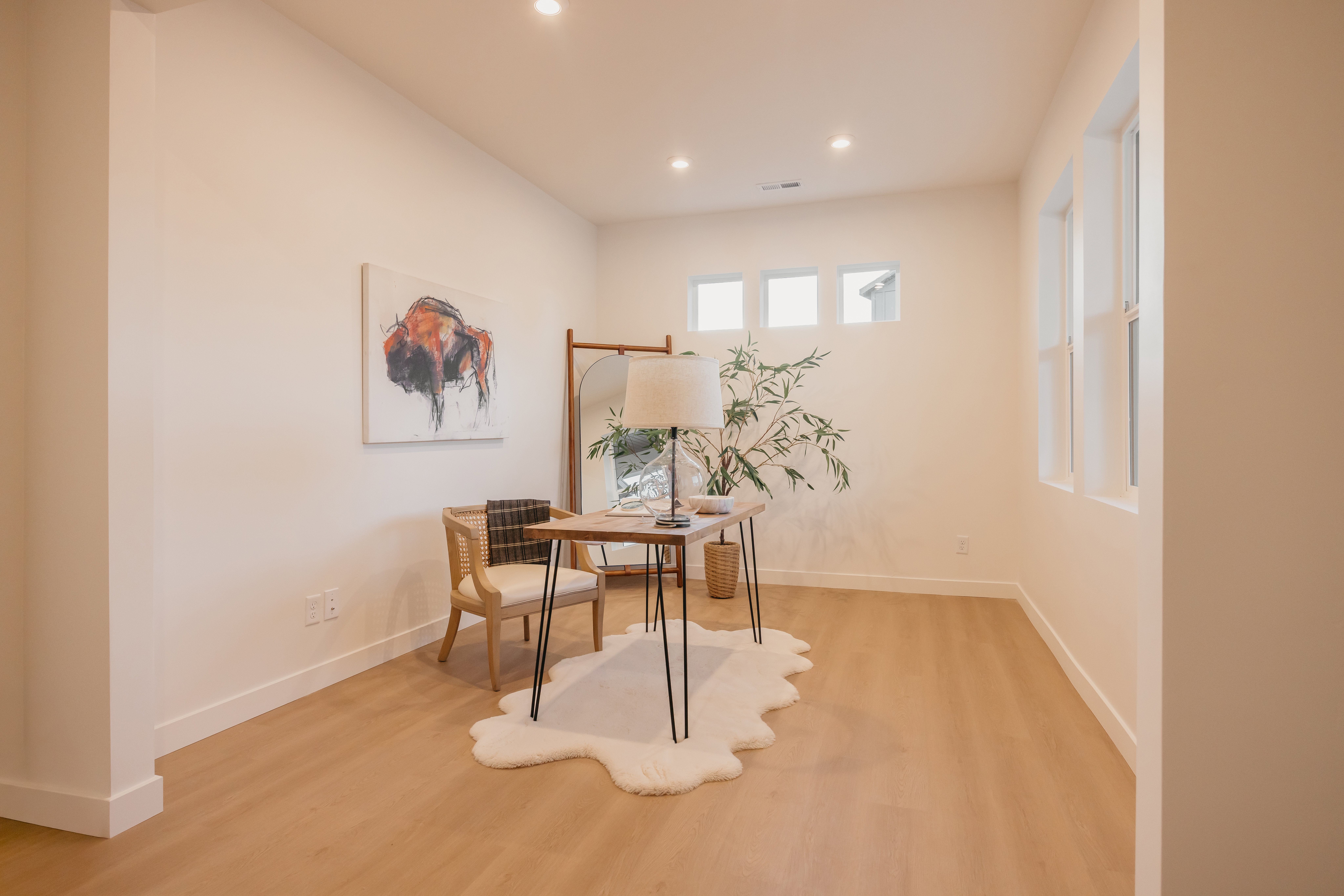 Spacious room featuring wood-finish flooring, recessed lighting, and multiple windows providing natural light