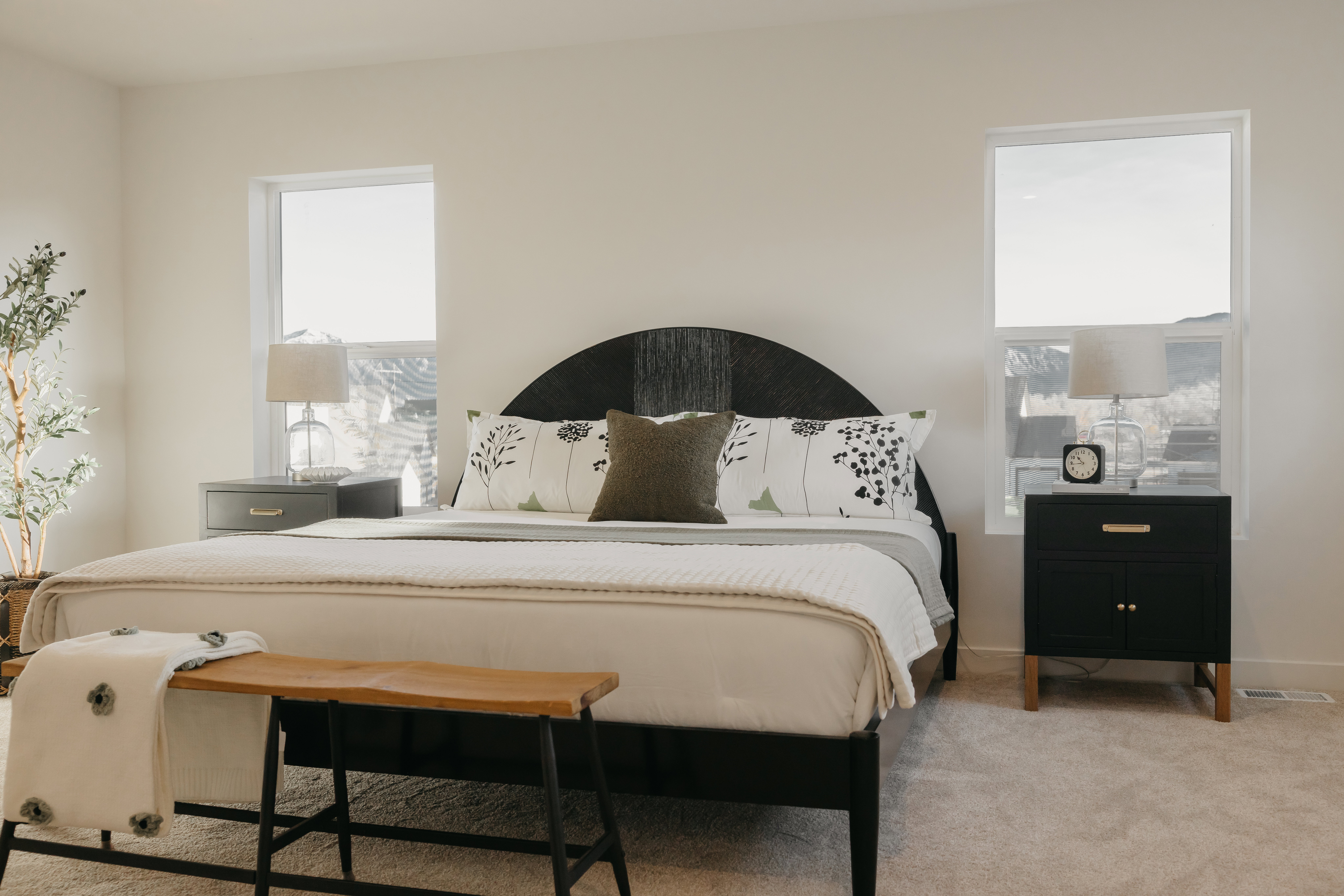 Bedroom featuring two large windows, neutral-toned walls, and plush carpeting