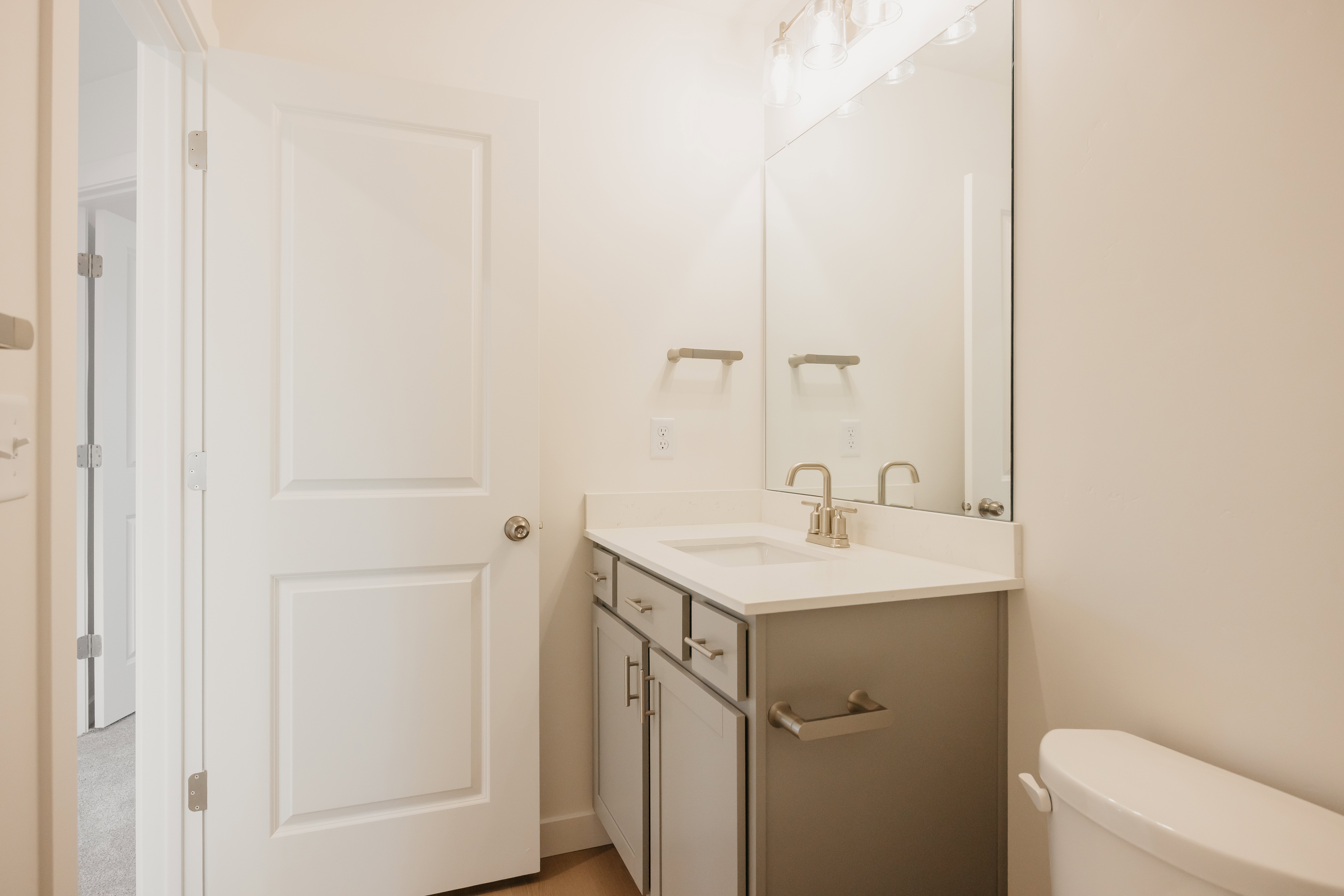 Bathroom featuring a vanity with a light gray cabinet, white countertop, and brushed nickel hardware