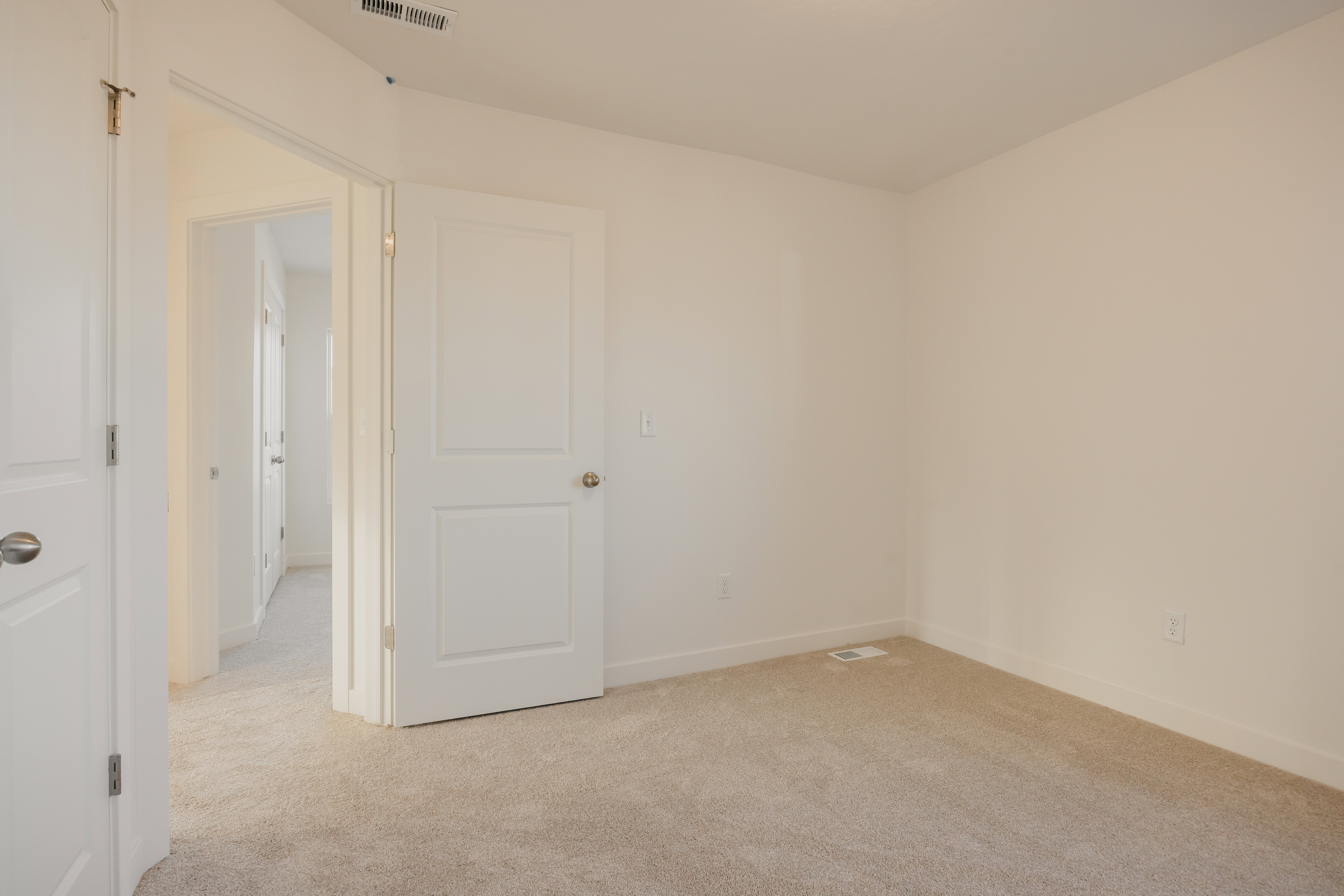 Neutral-toned walls complement plush carpet flooring