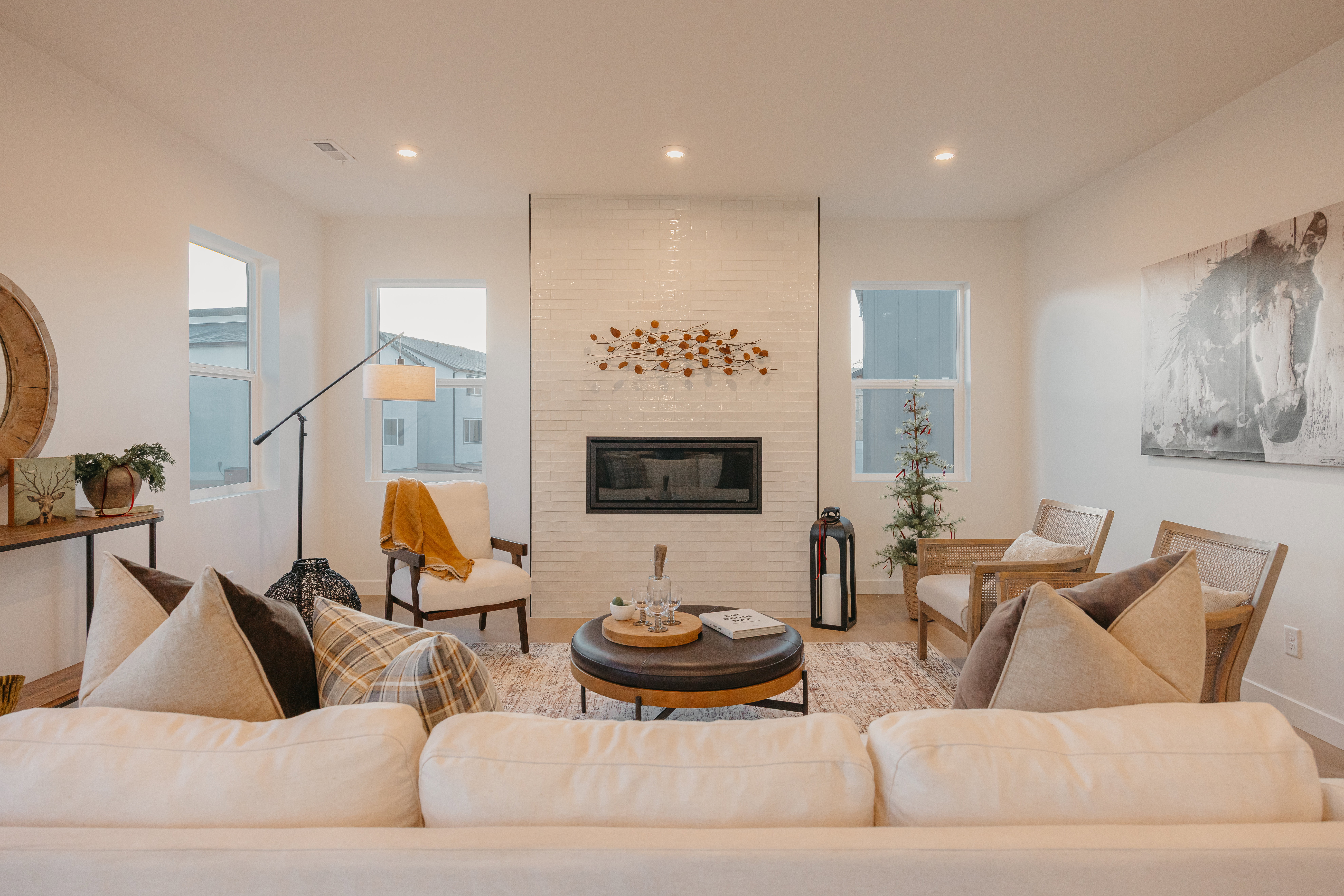 Living area featuring a vertical tile fireplace with a black insert, wood-finish flooring, recessed lighting, and multiple windows