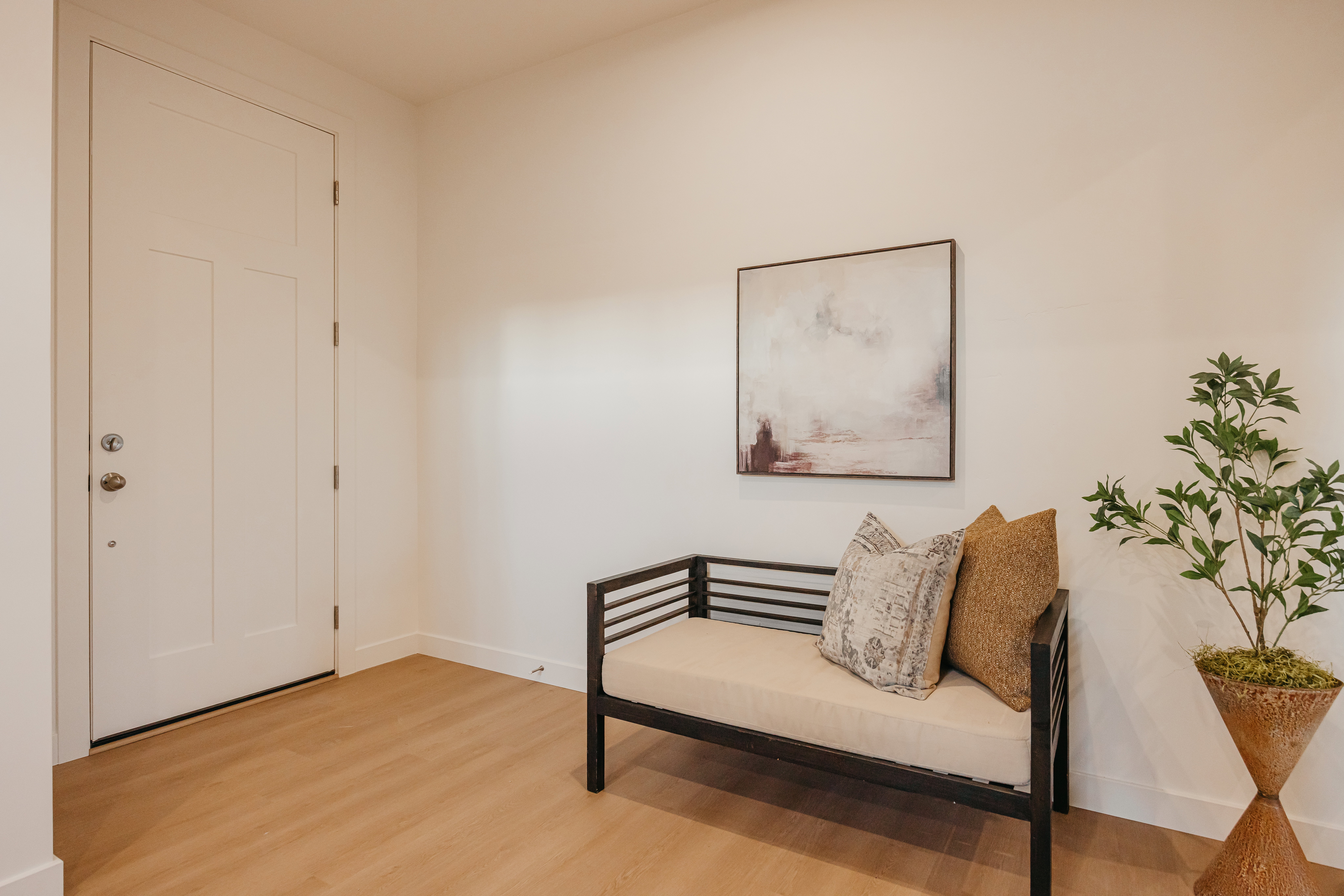 Entryway featuring light wood-finish flooring, white baseboards, and a white paneled door with brushed nickel hardware
