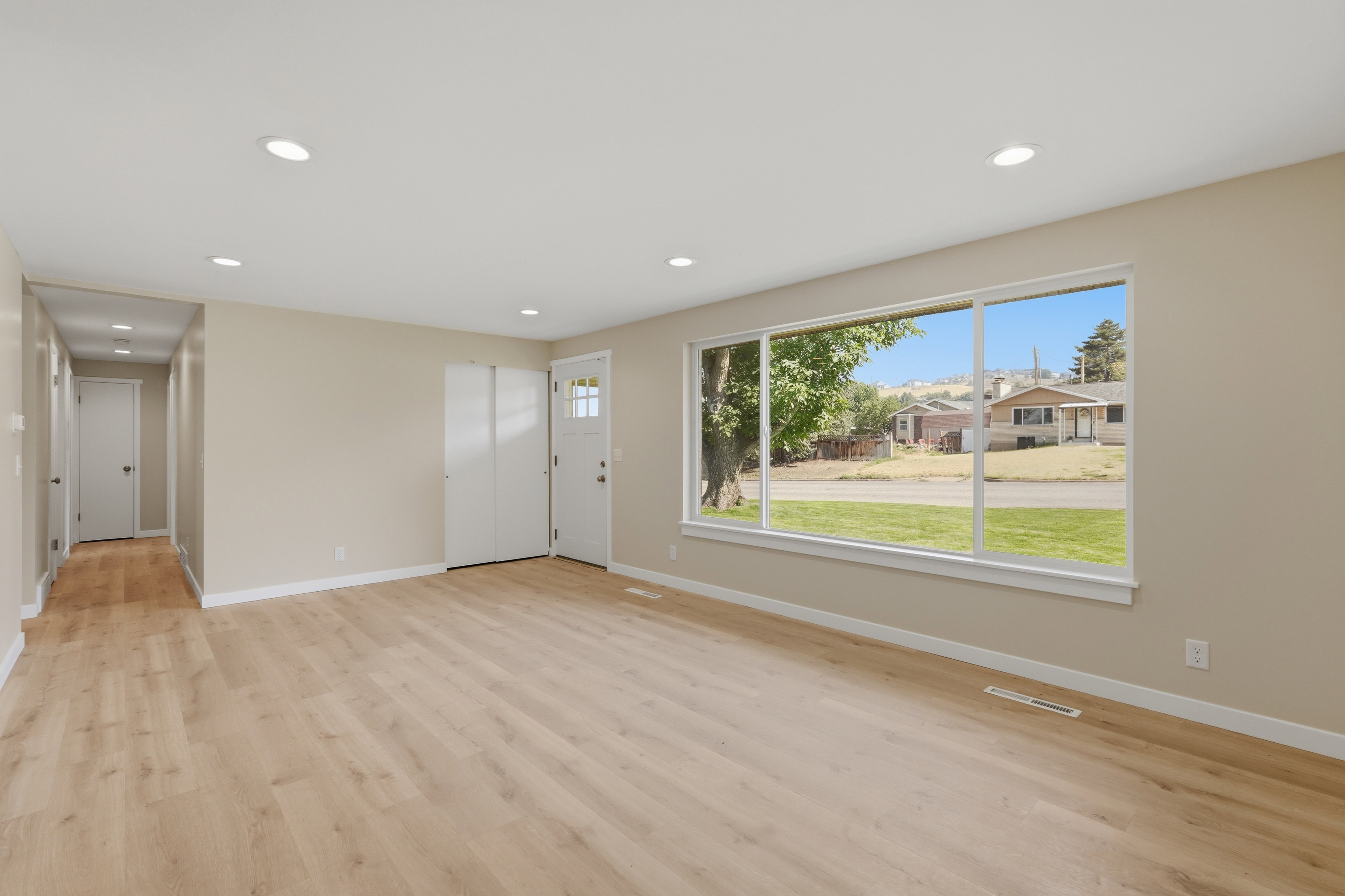 Spacious room featuring light wood-finish flooring and a large picture window