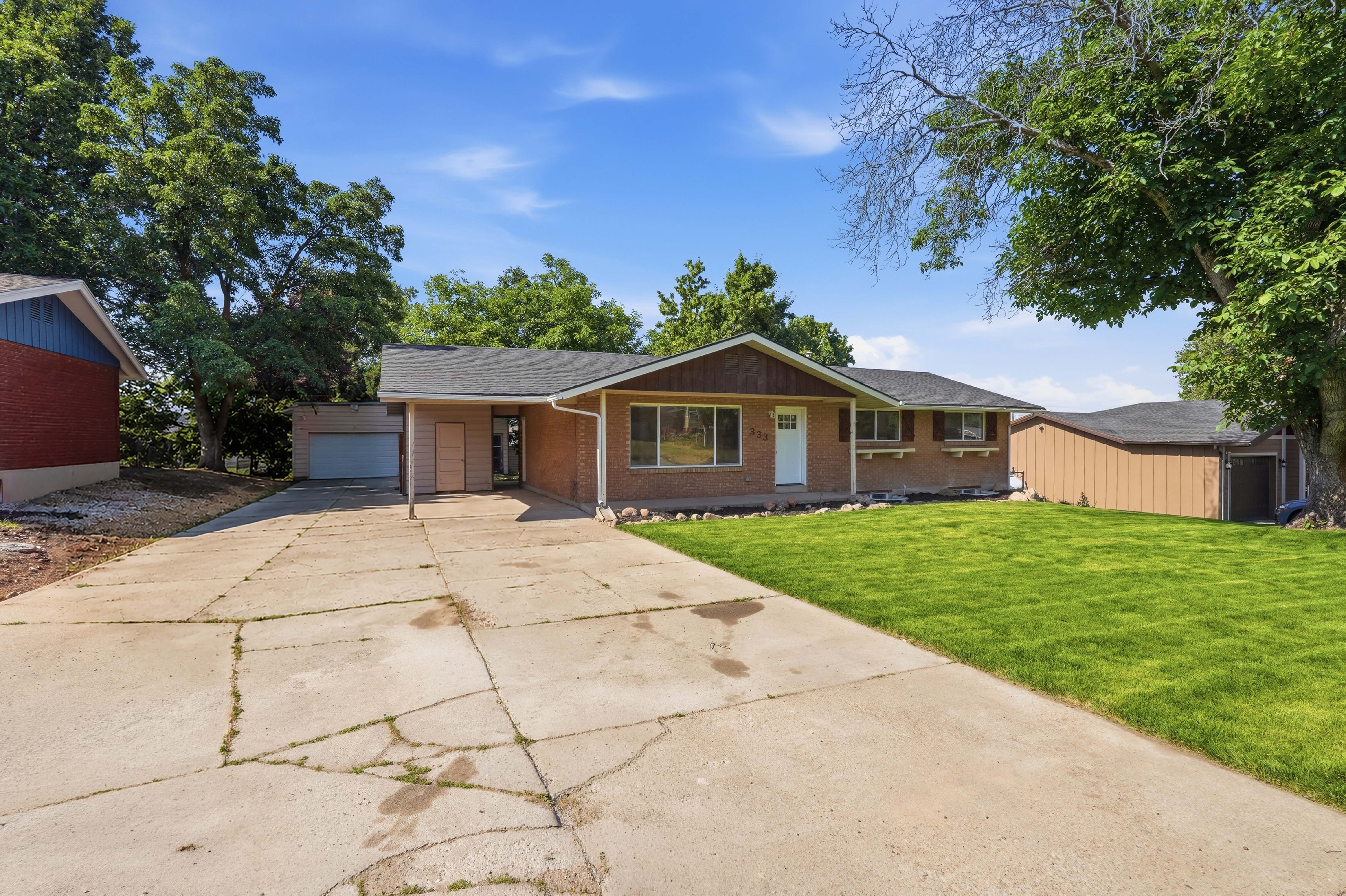 Ranch-style residence featuring a brick facade, covered entry, and a single-car garage