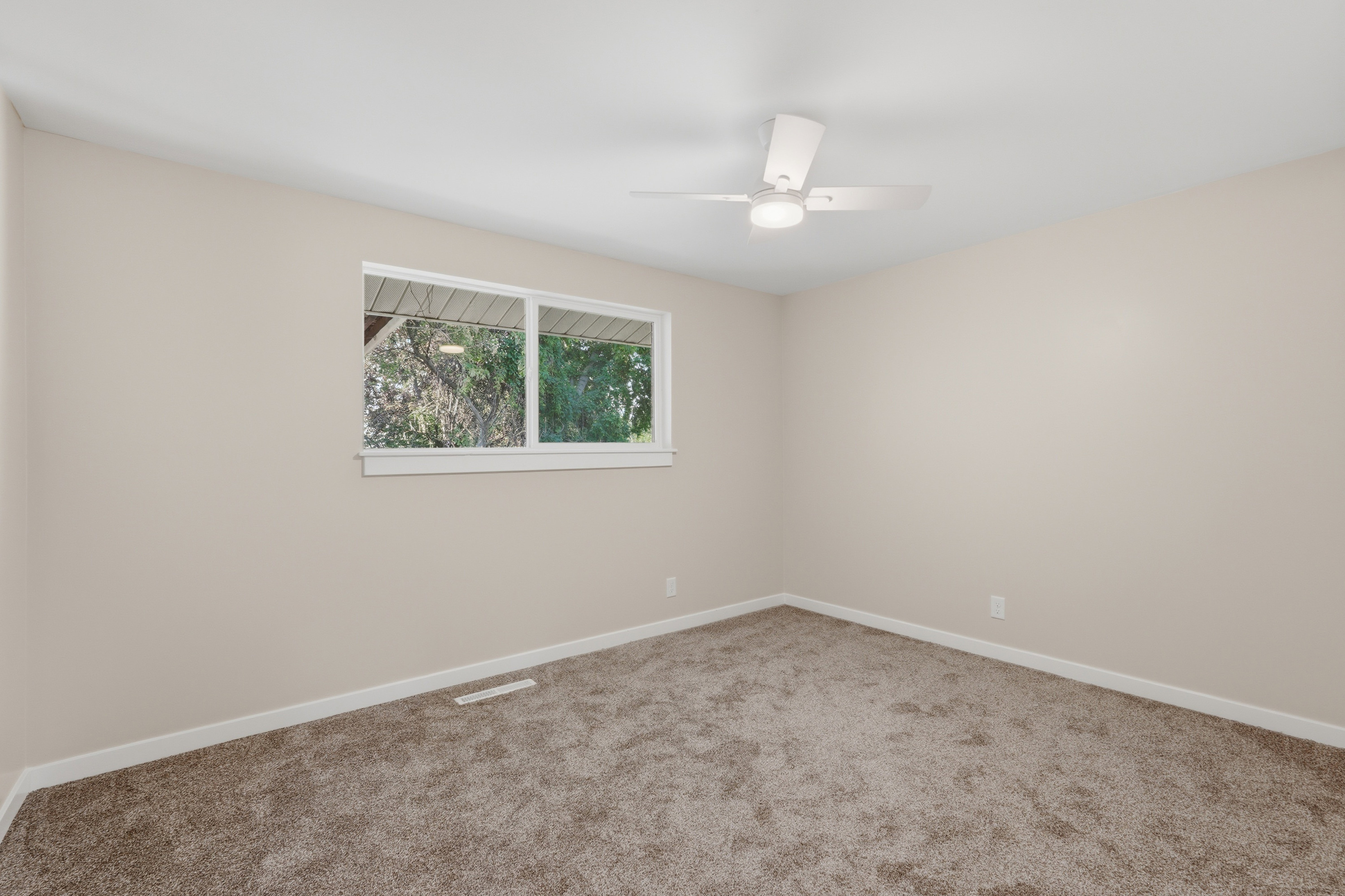 Neutral-toned walls and plush carpeting complement the white trim