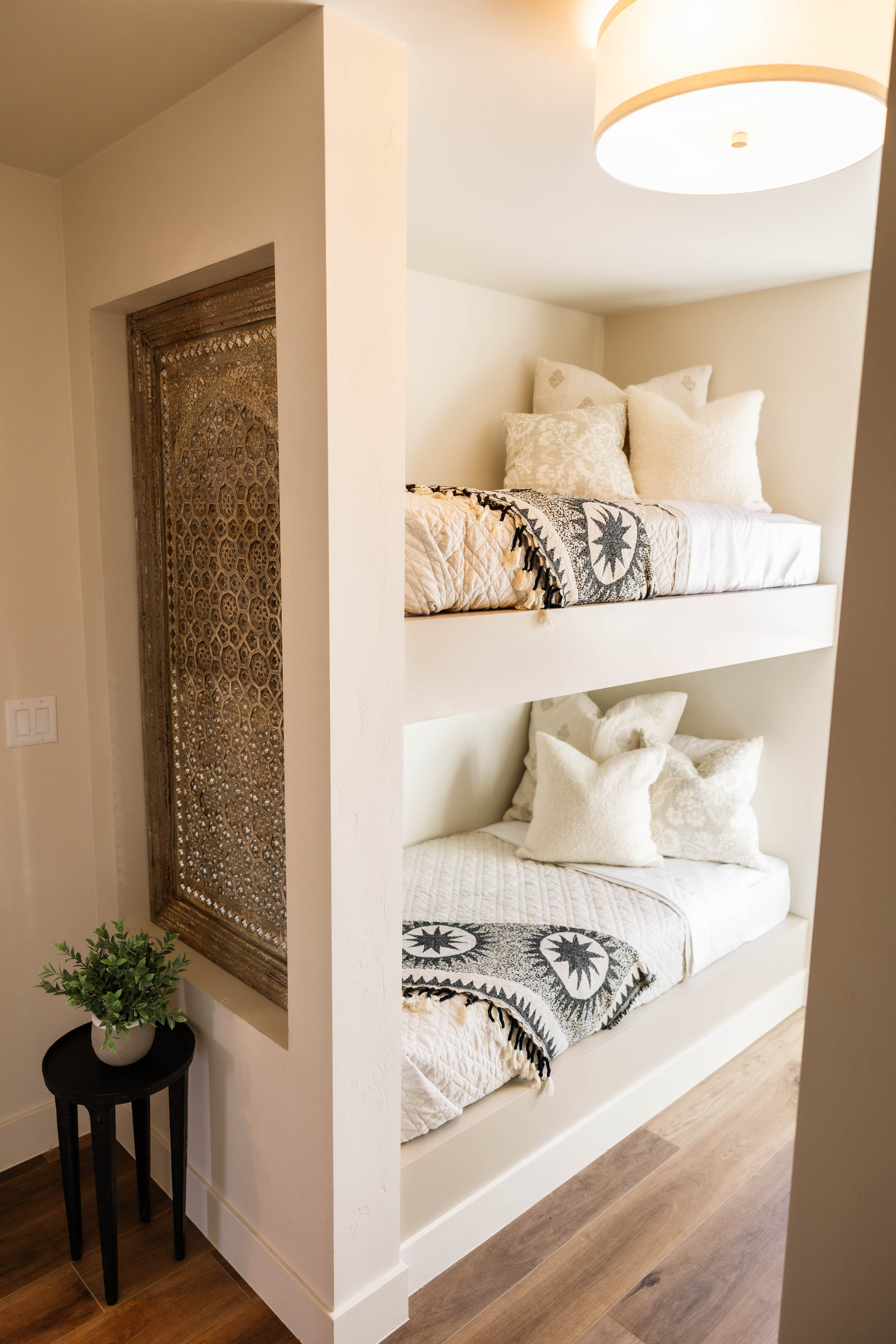 Built-in bunk beds with recessed lighting and warm wood-finish flooring