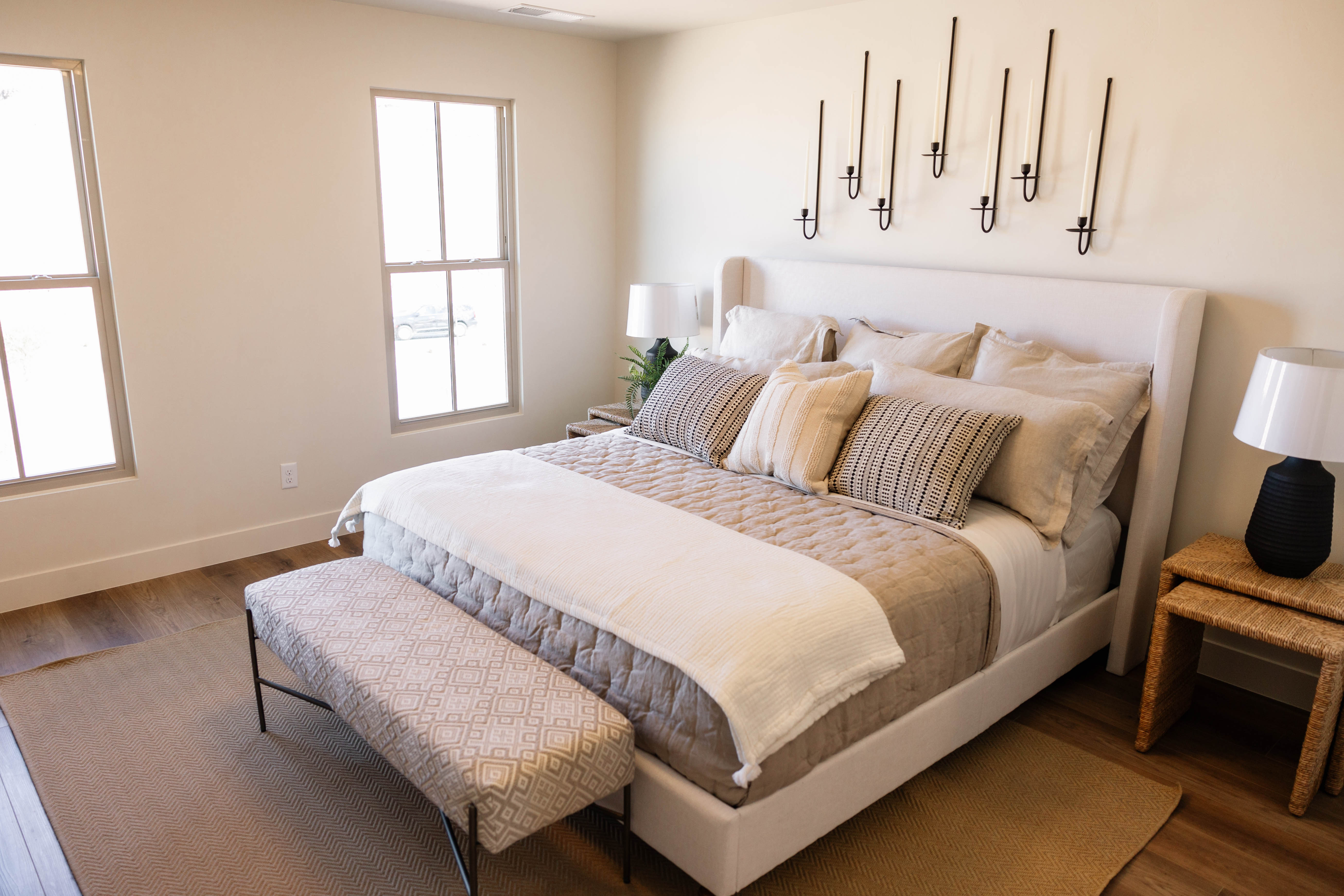 Spacious room featuring wood-finish flooring, two large windows, and neutral wall tones