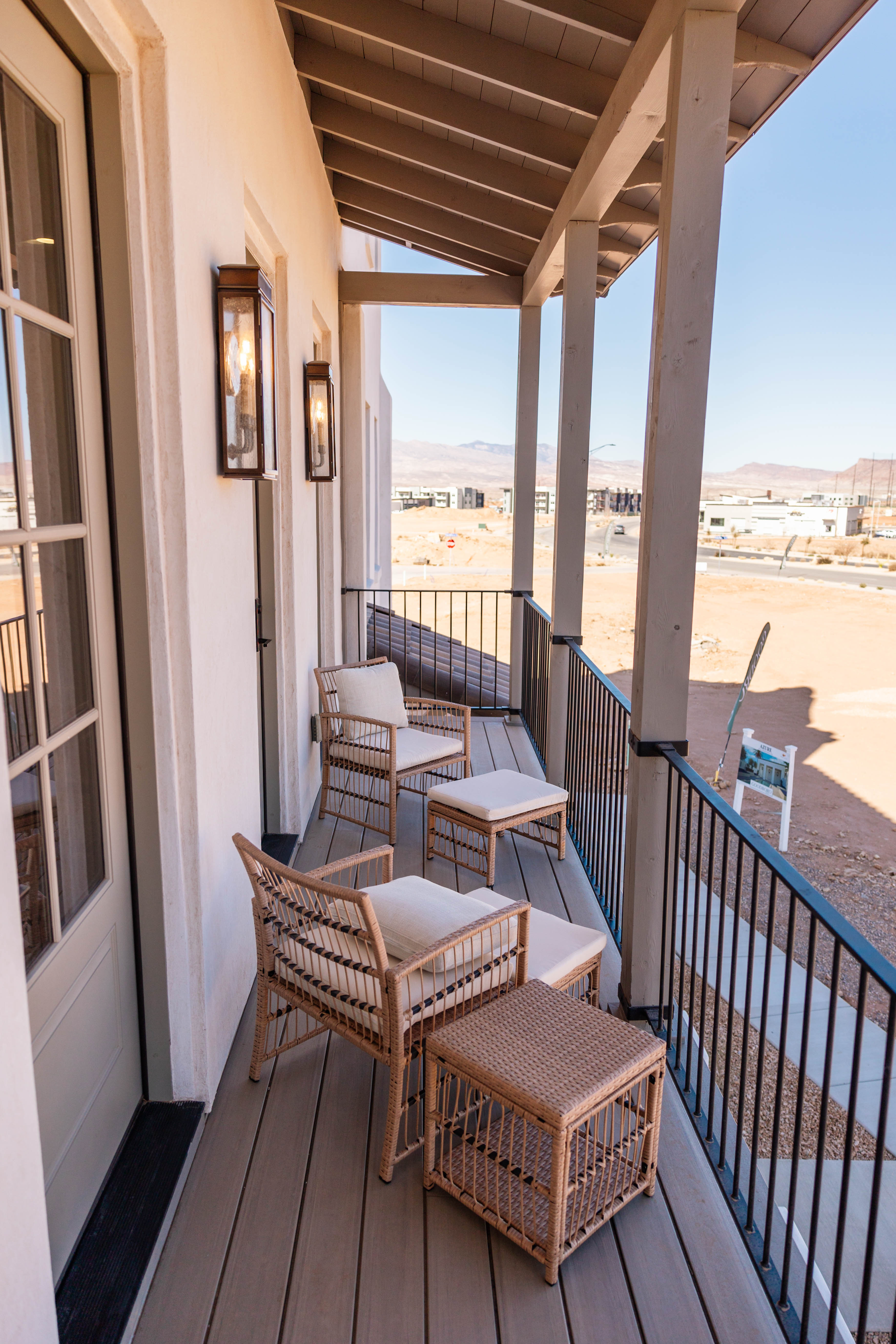Covered balcony featuring a wood-finish floor and black metal railings