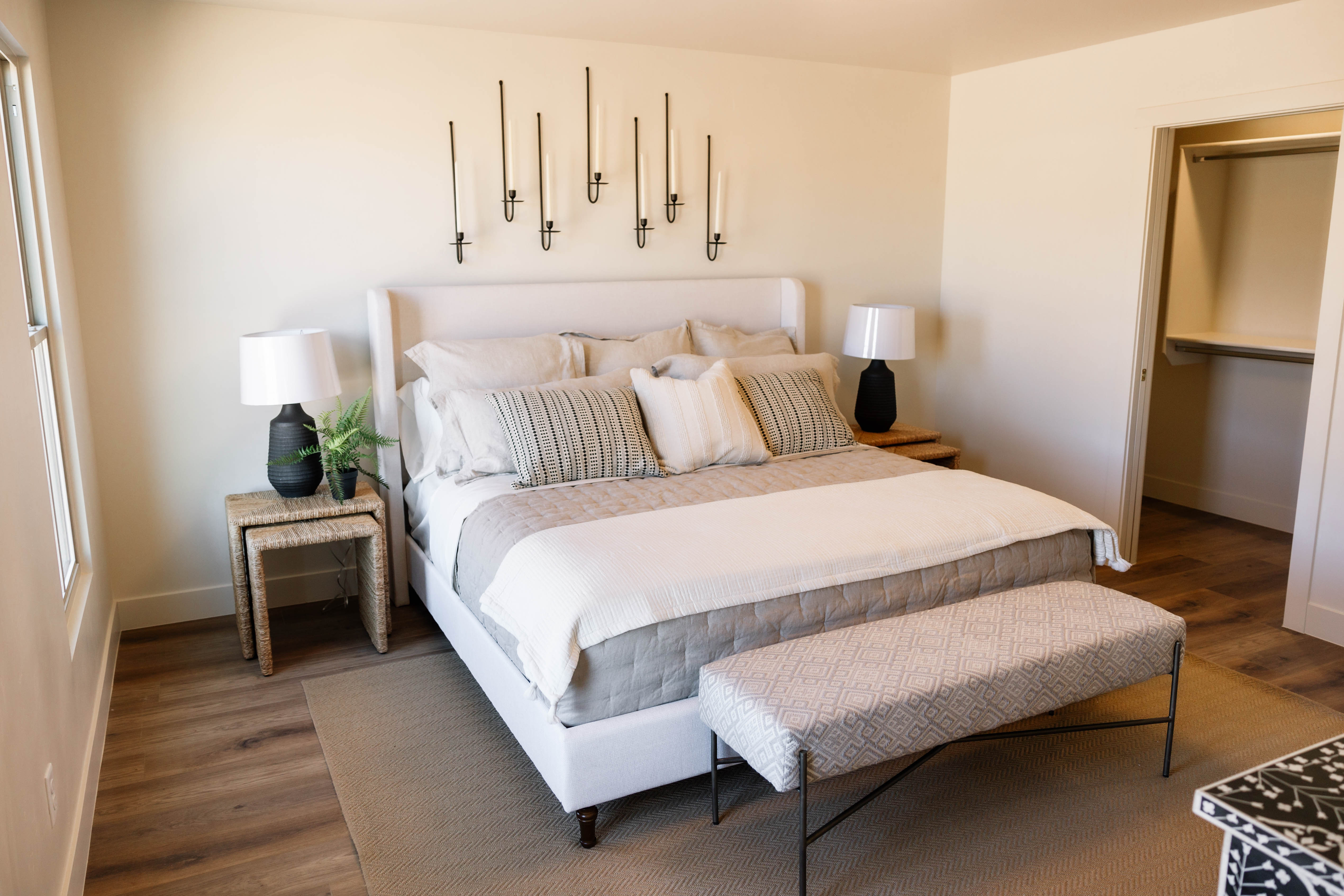Spacious bedroom featuring wood-finish flooring, a window, and a built-in closet with shelving