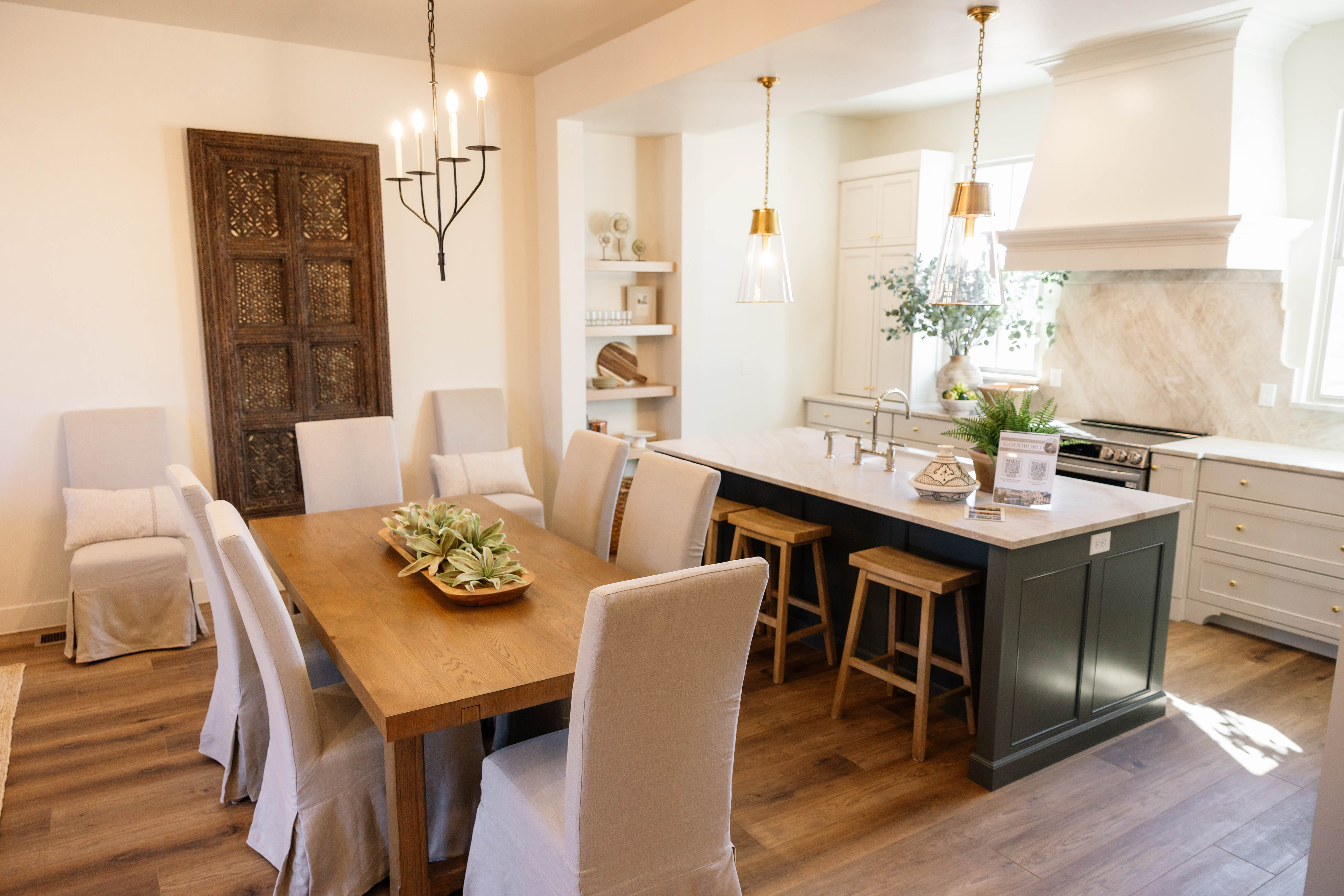 Gourmet kitchen and dining area featuring a spacious island, custom cabinetry, stainless steel appliances, and wood-finish flooring